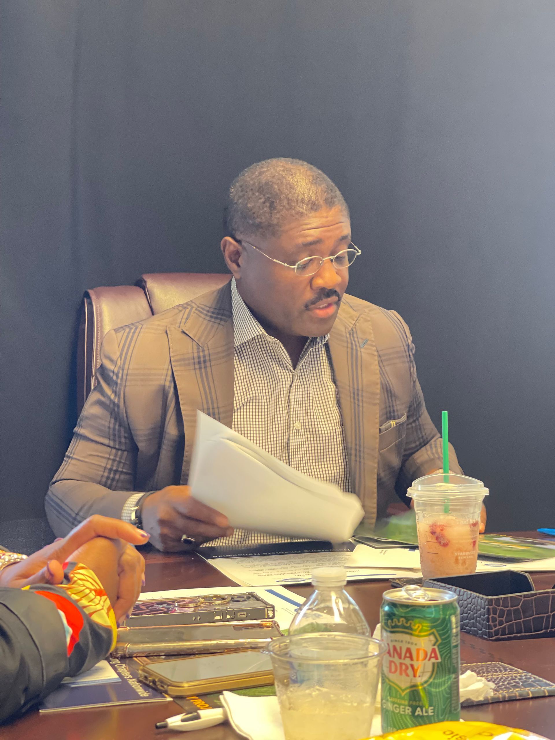 A man is sitting at a table with a can of jamaica rum.