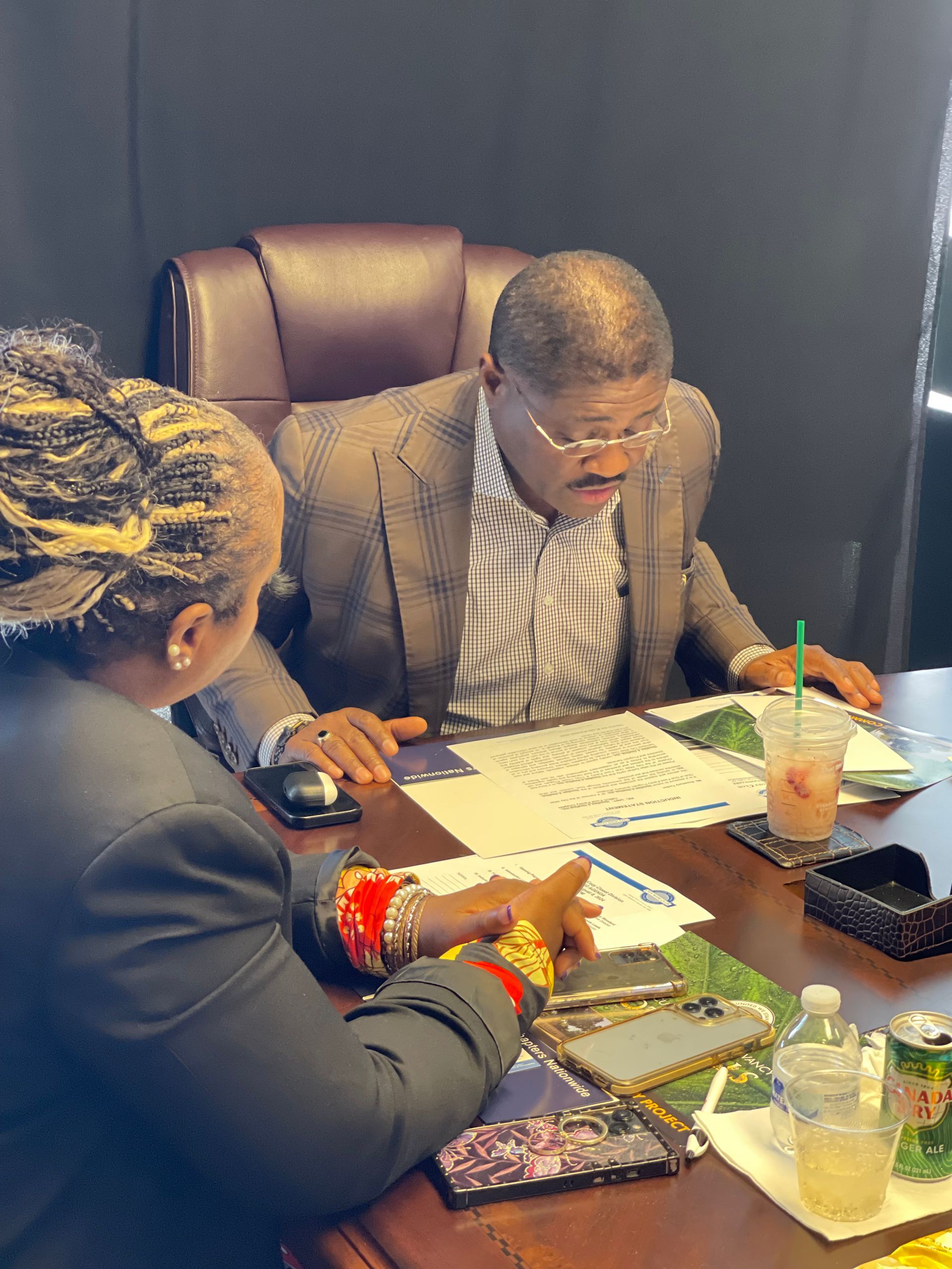 A man and a woman are sitting at a table looking at papers.