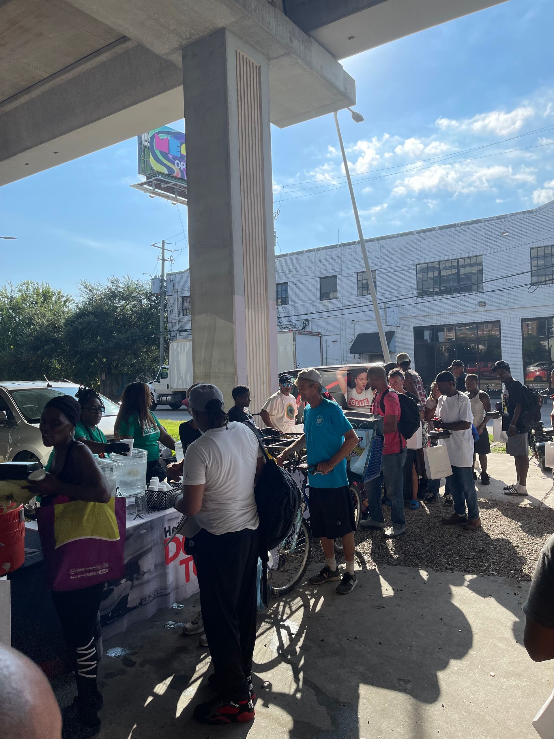 A group of people are standing around a table in front of a building.