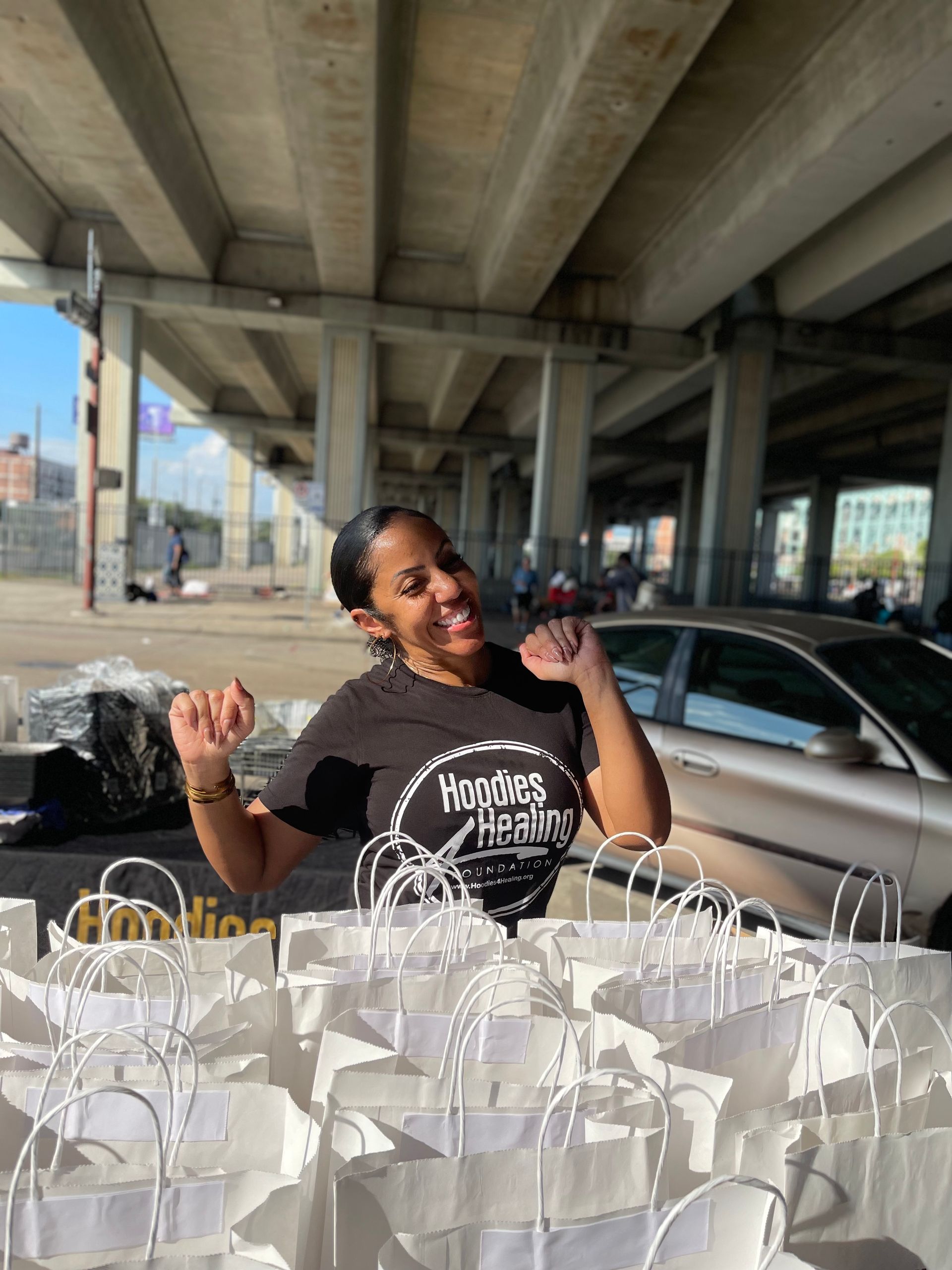 A woman is standing in front of a pile of paper bags.