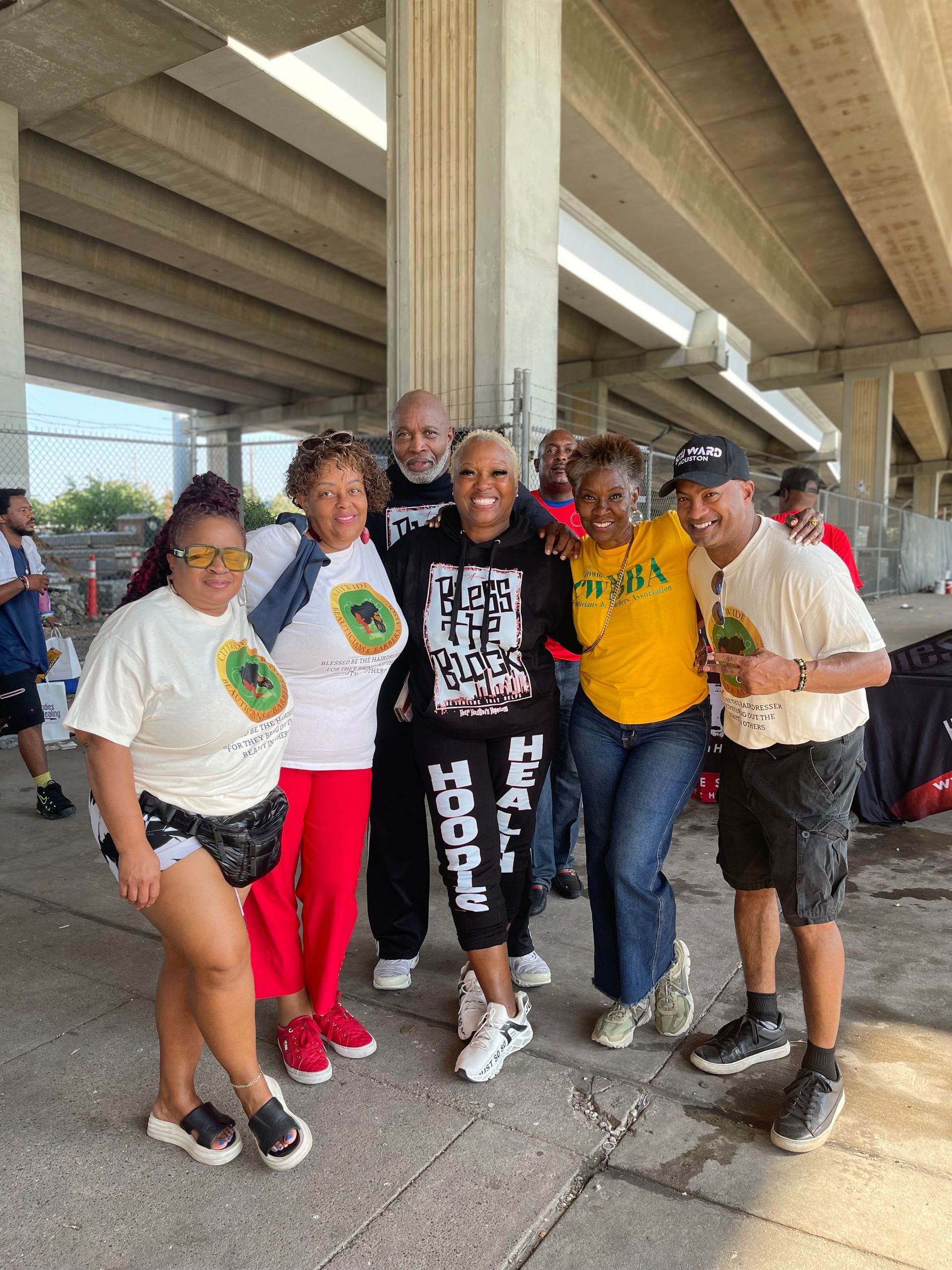 A group of people are posing for a picture under a bridge.