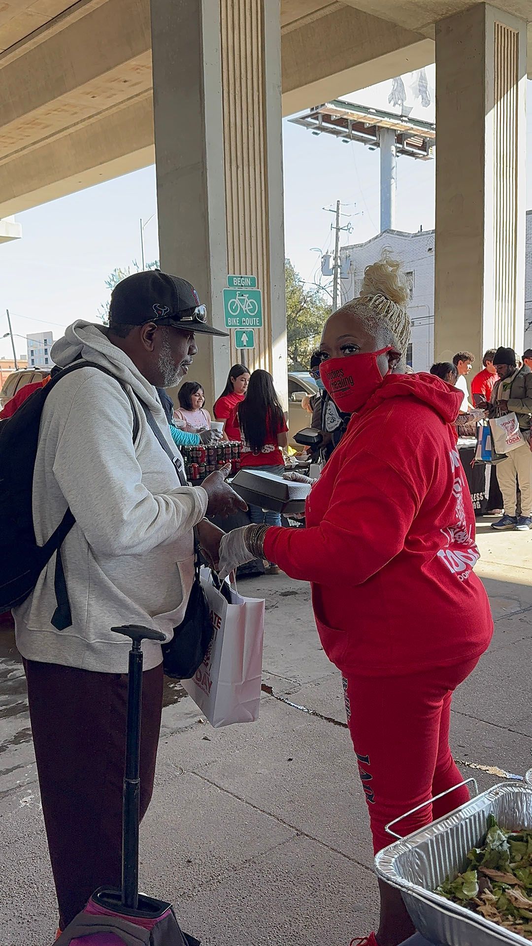 A man and a woman are standing next to each other under a bridge.