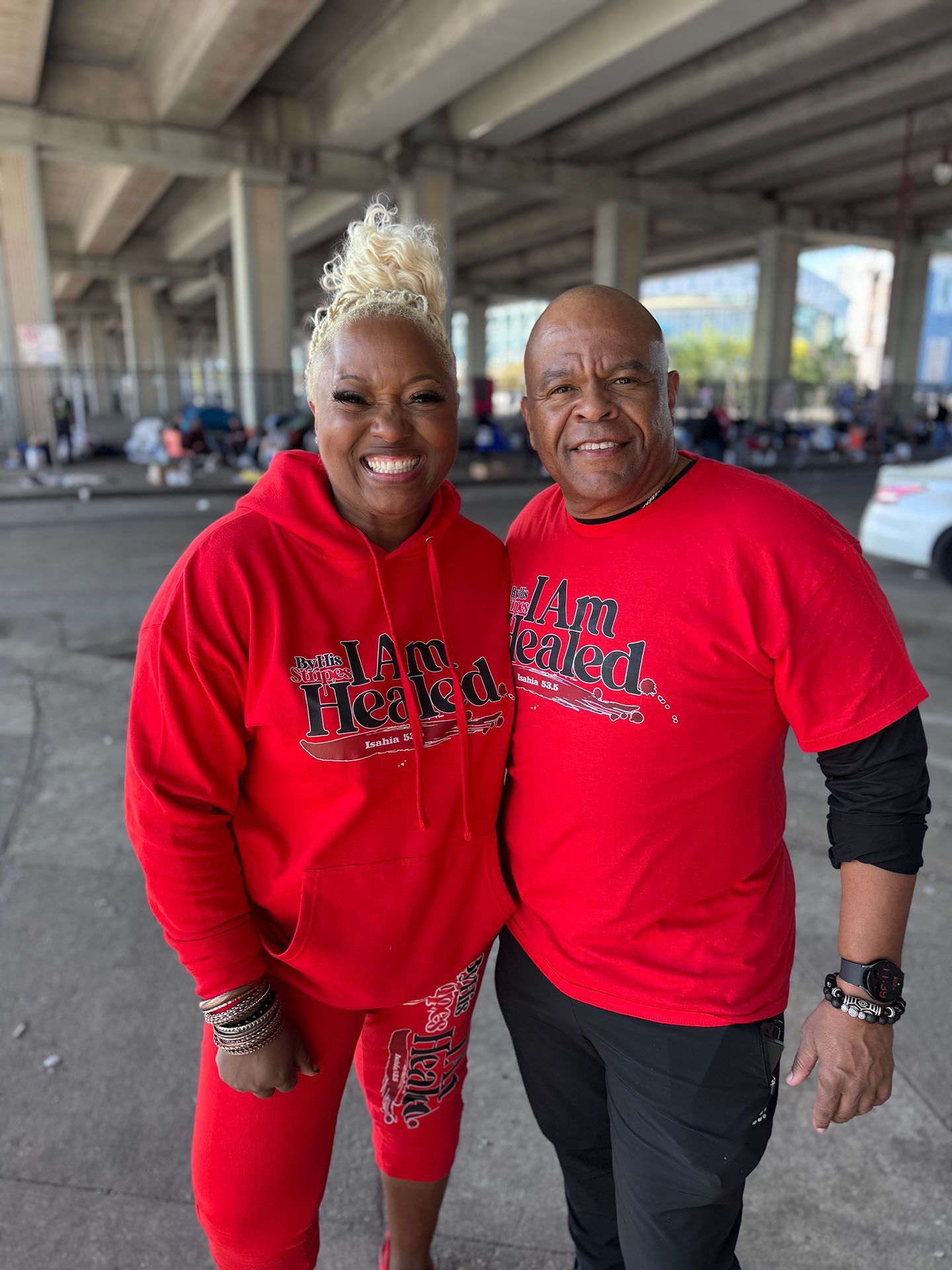 A man and a woman wearing red shirts are posing for a picture.