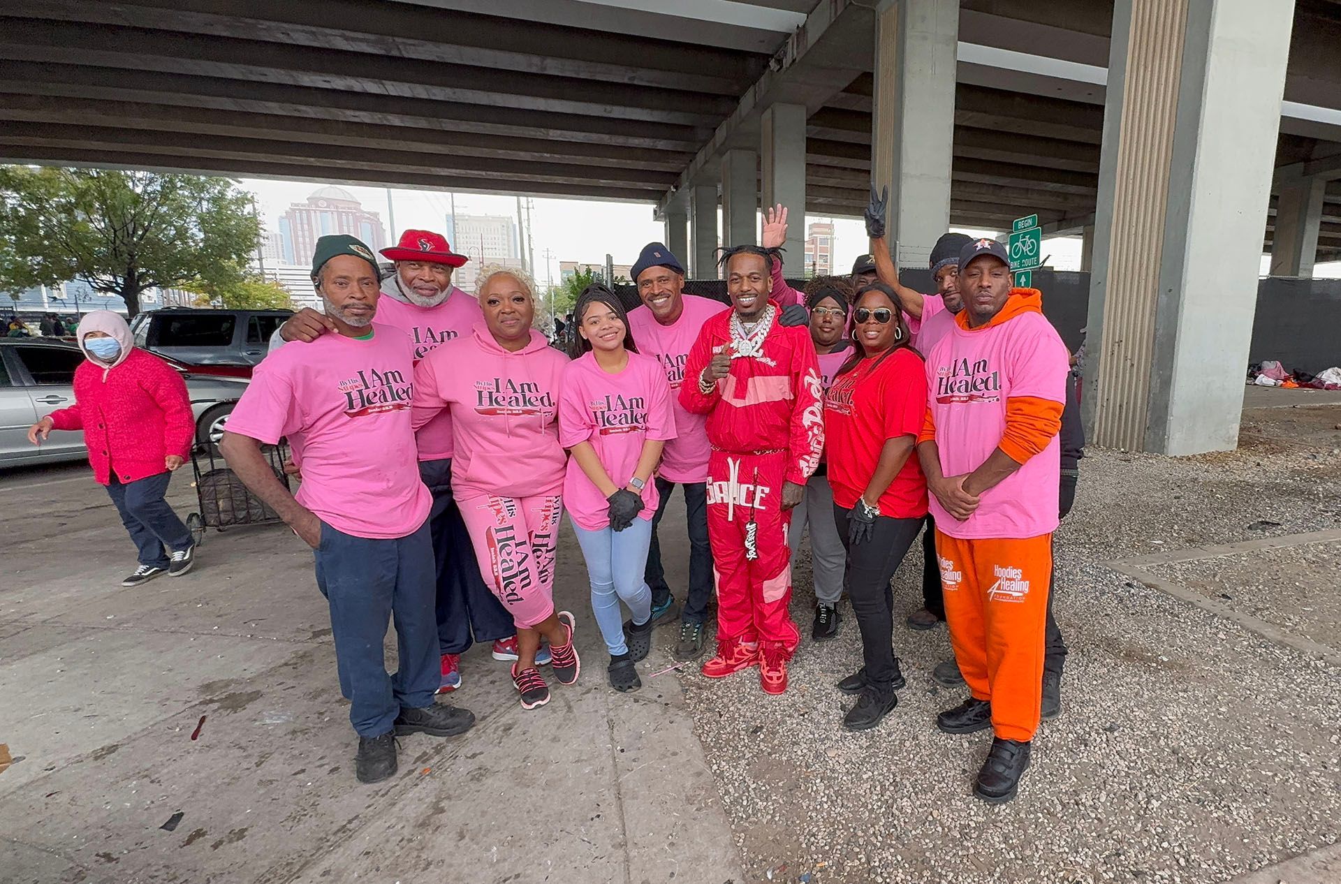 A group of people are posing for a picture under a bridge.
