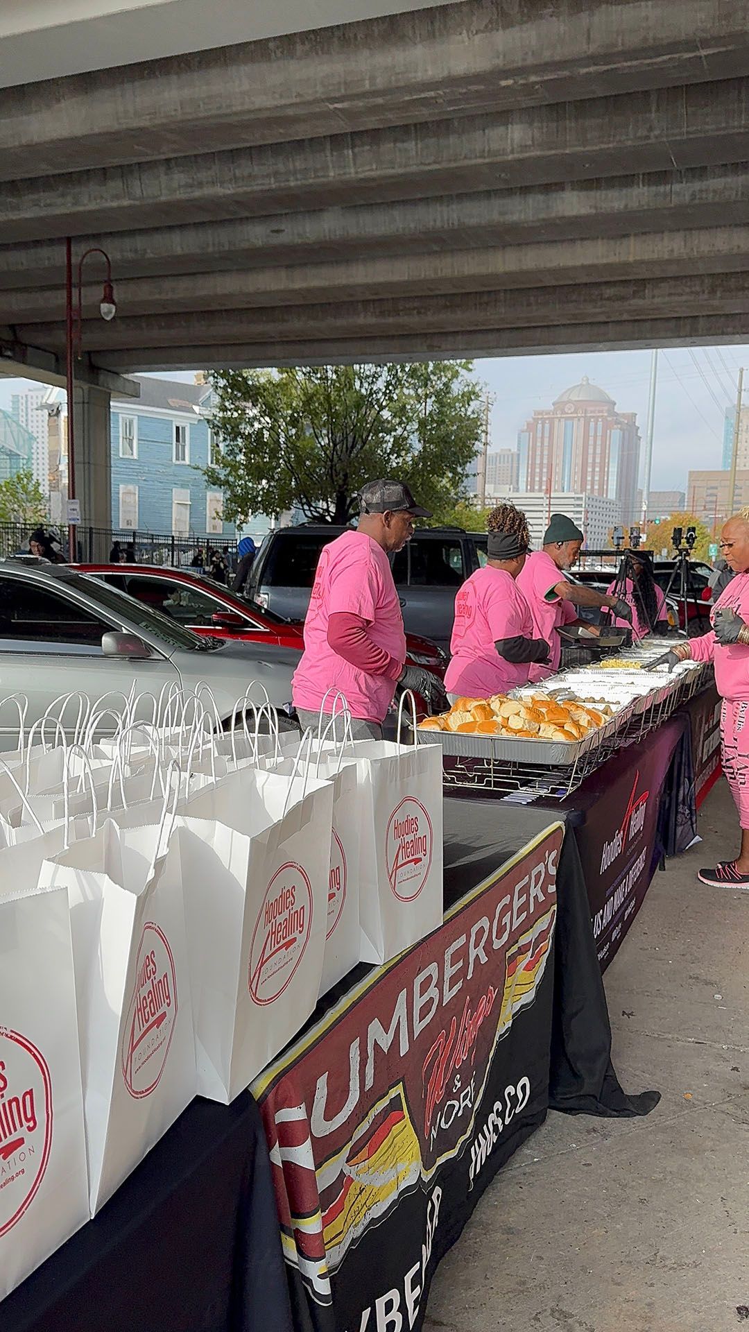 A group of people in pink shirts are standing around a table.