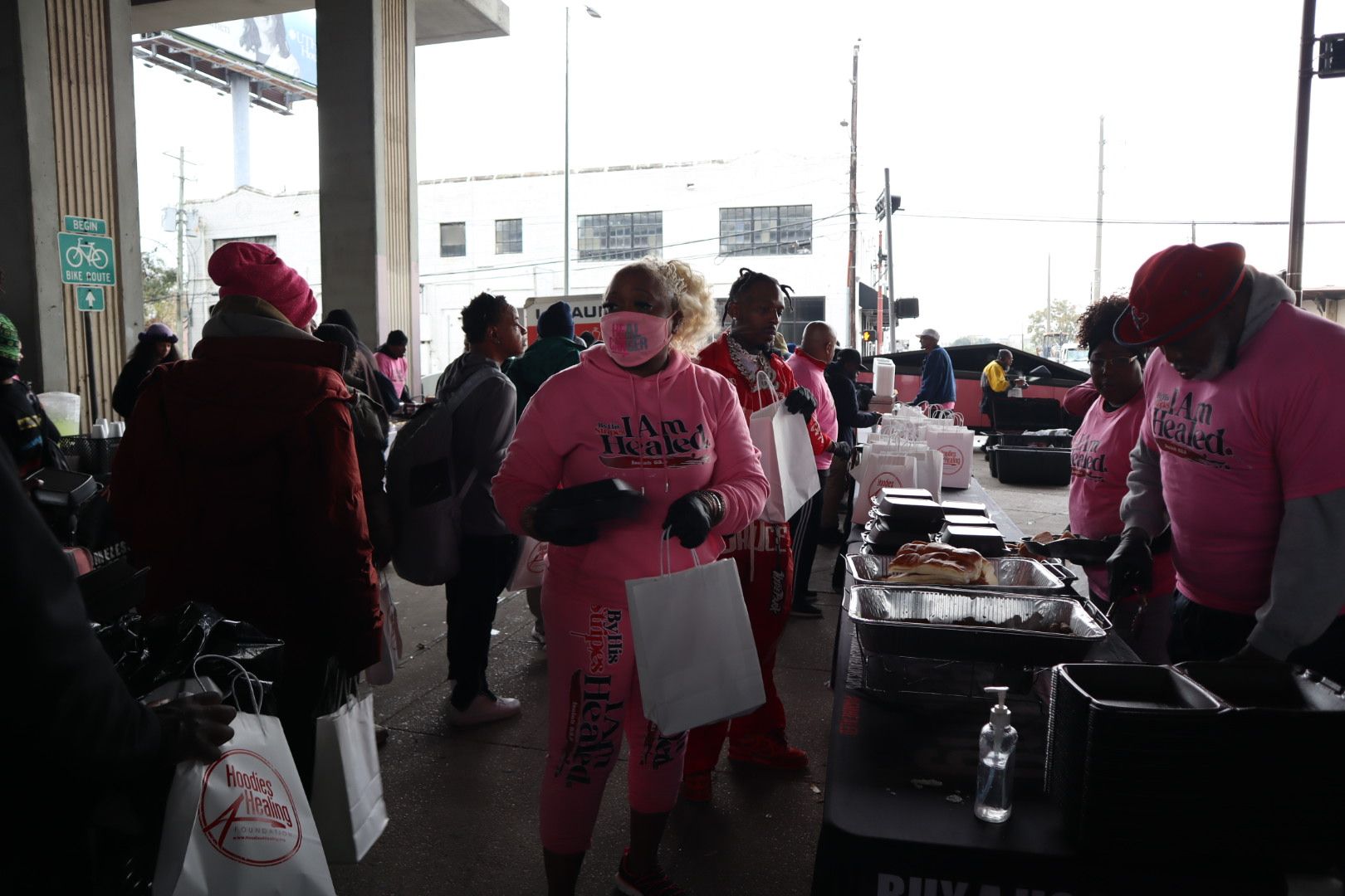A group of people in pink shirts are standing around a table.