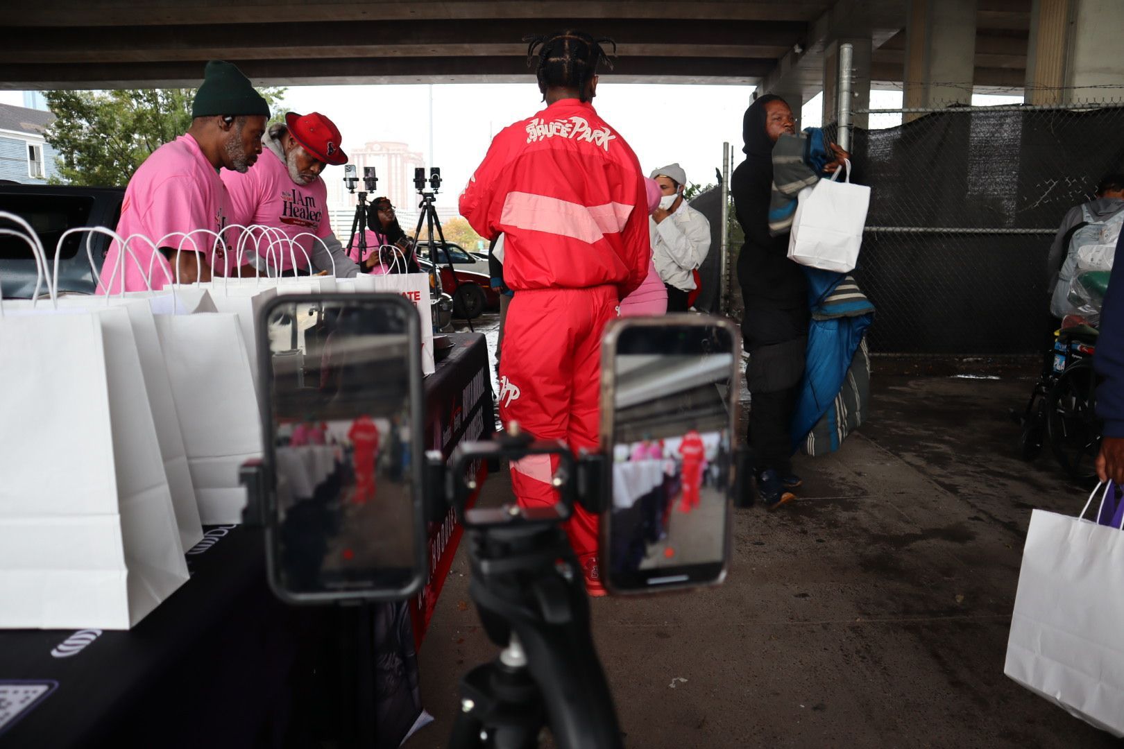 A man in a red jacket is standing in front of a mirror.
