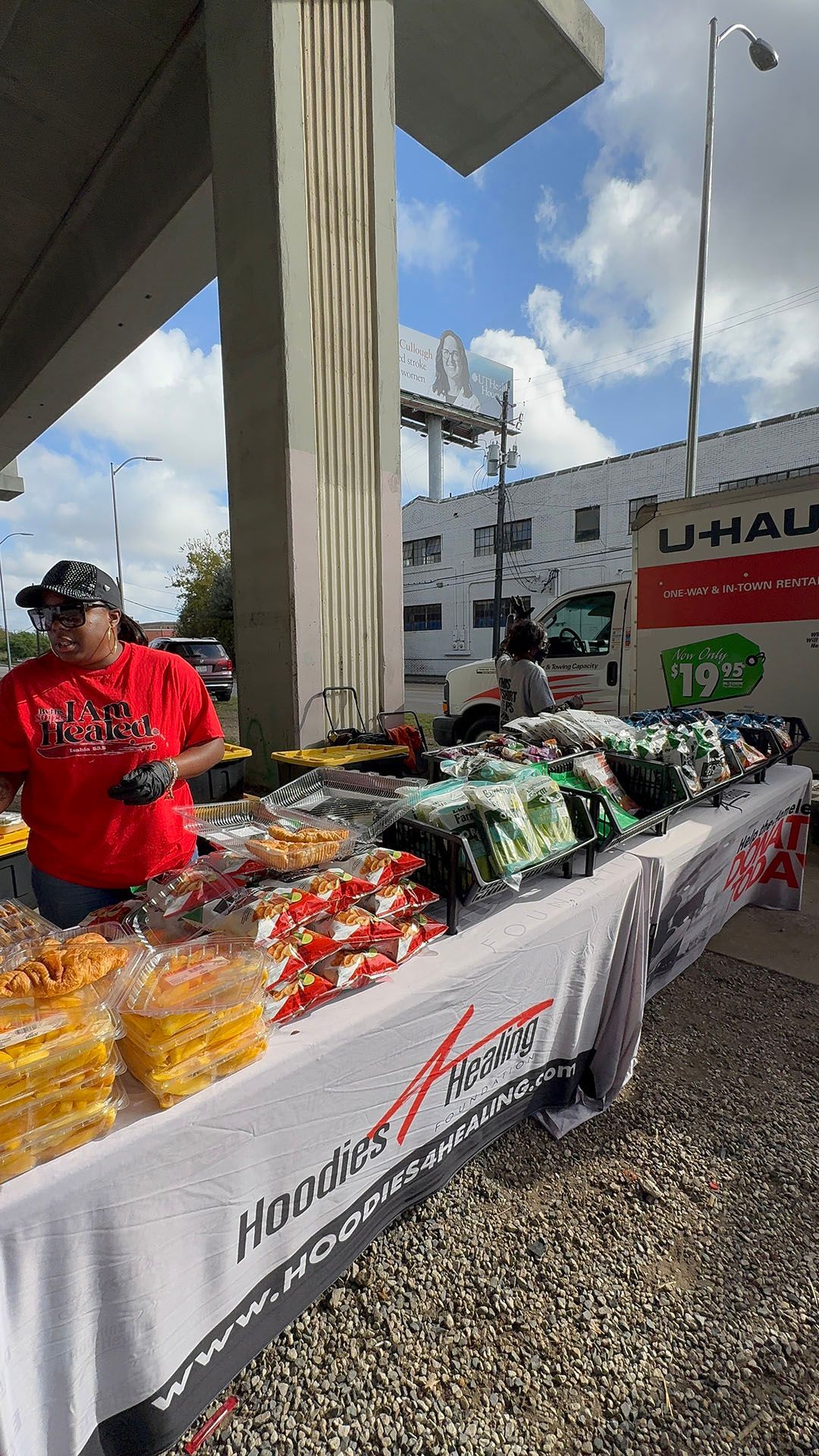 A man is standing behind a table filled with food.