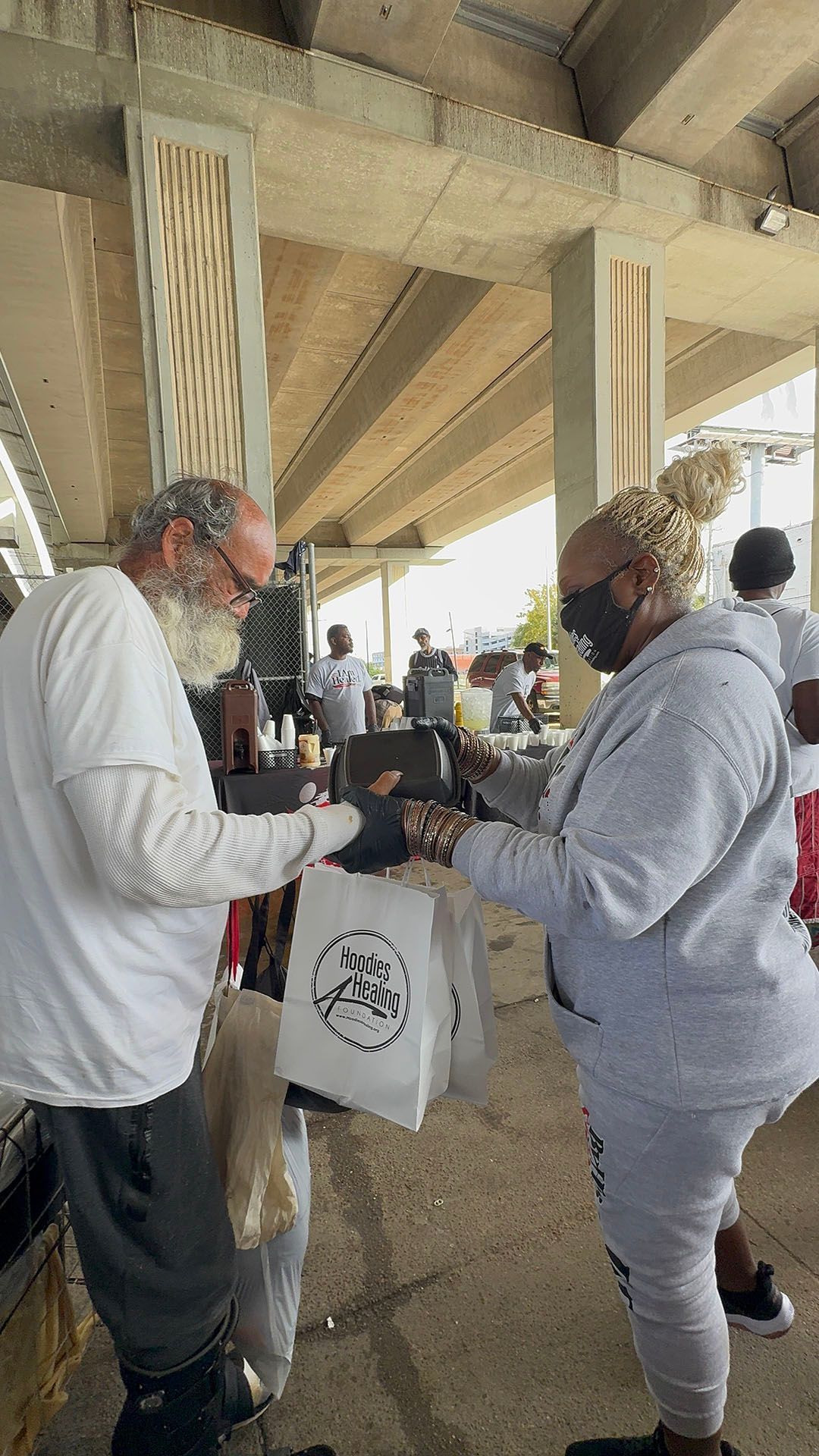 A man and a woman are standing next to each other under a bridge.