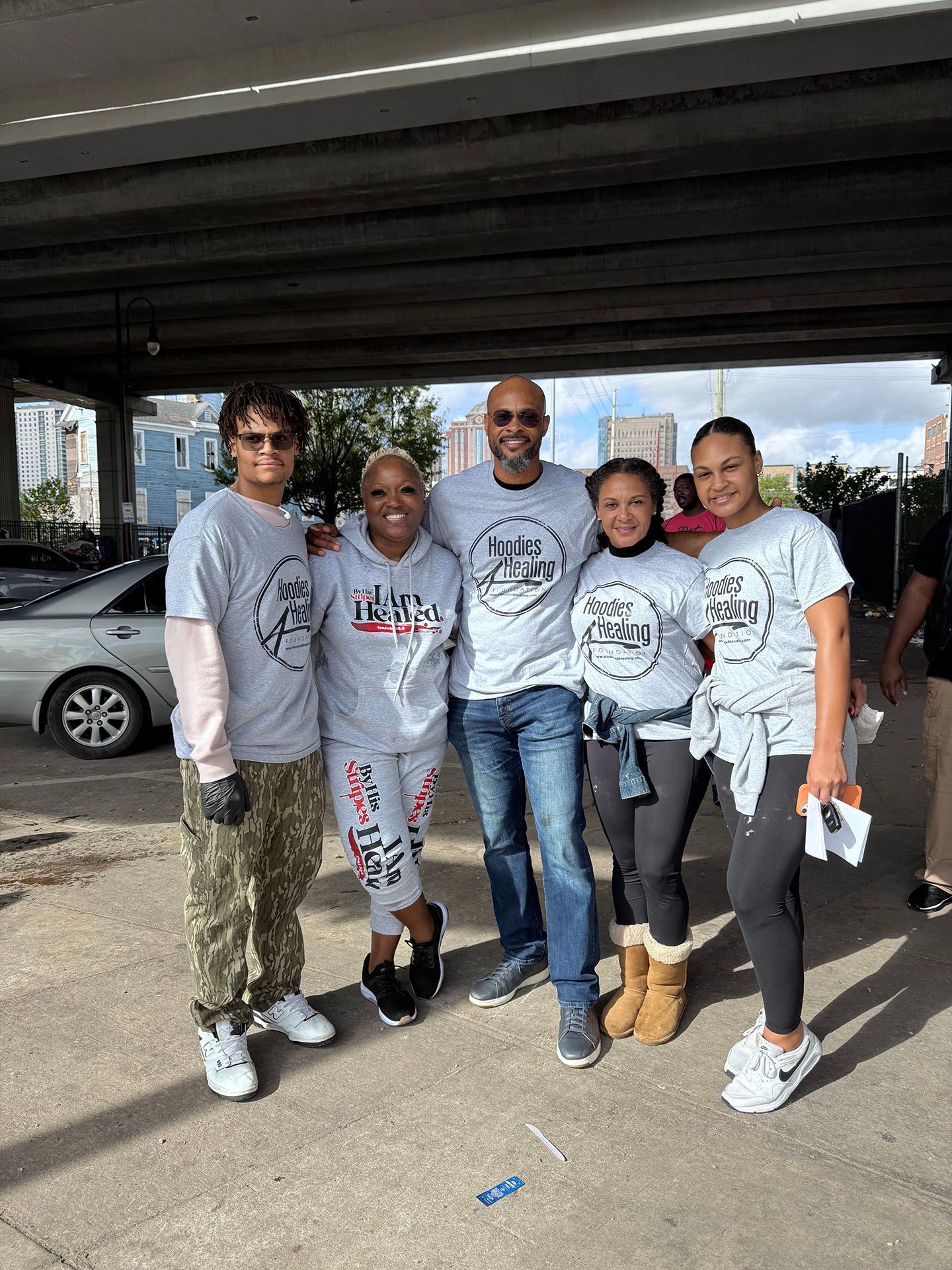 A group of people are posing for a picture under a bridge.