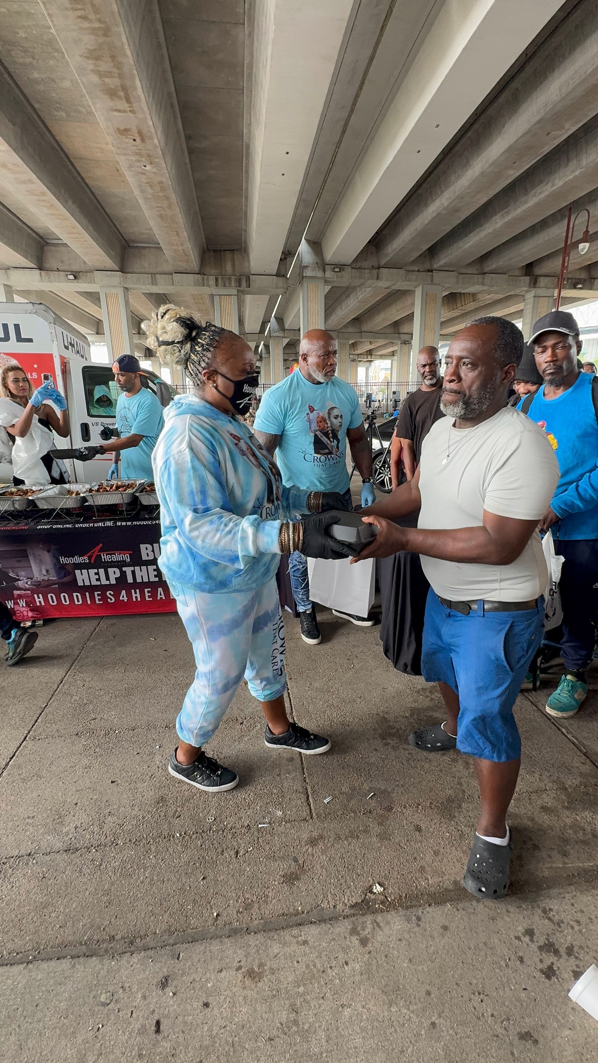 A group of people are shaking hands under a bridge.
