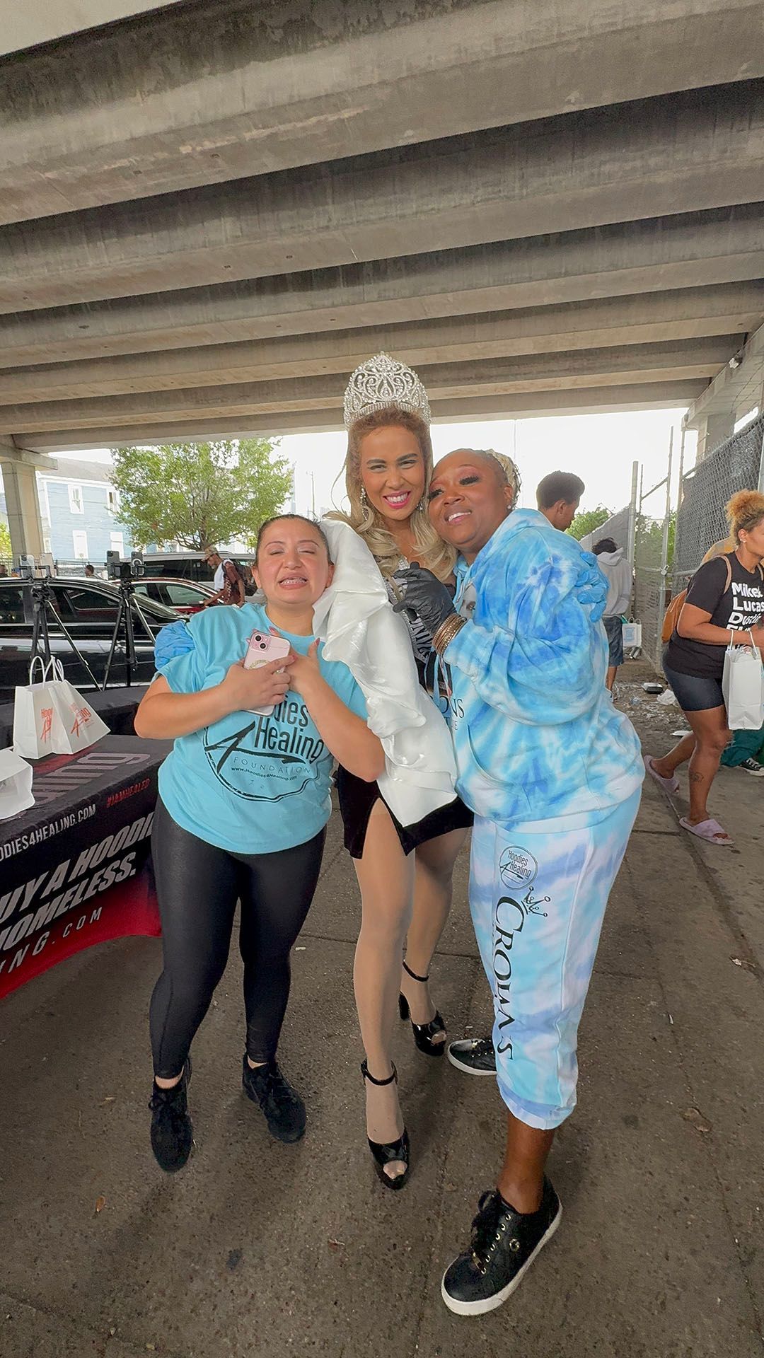 A group of women are posing for a picture under a bridge.