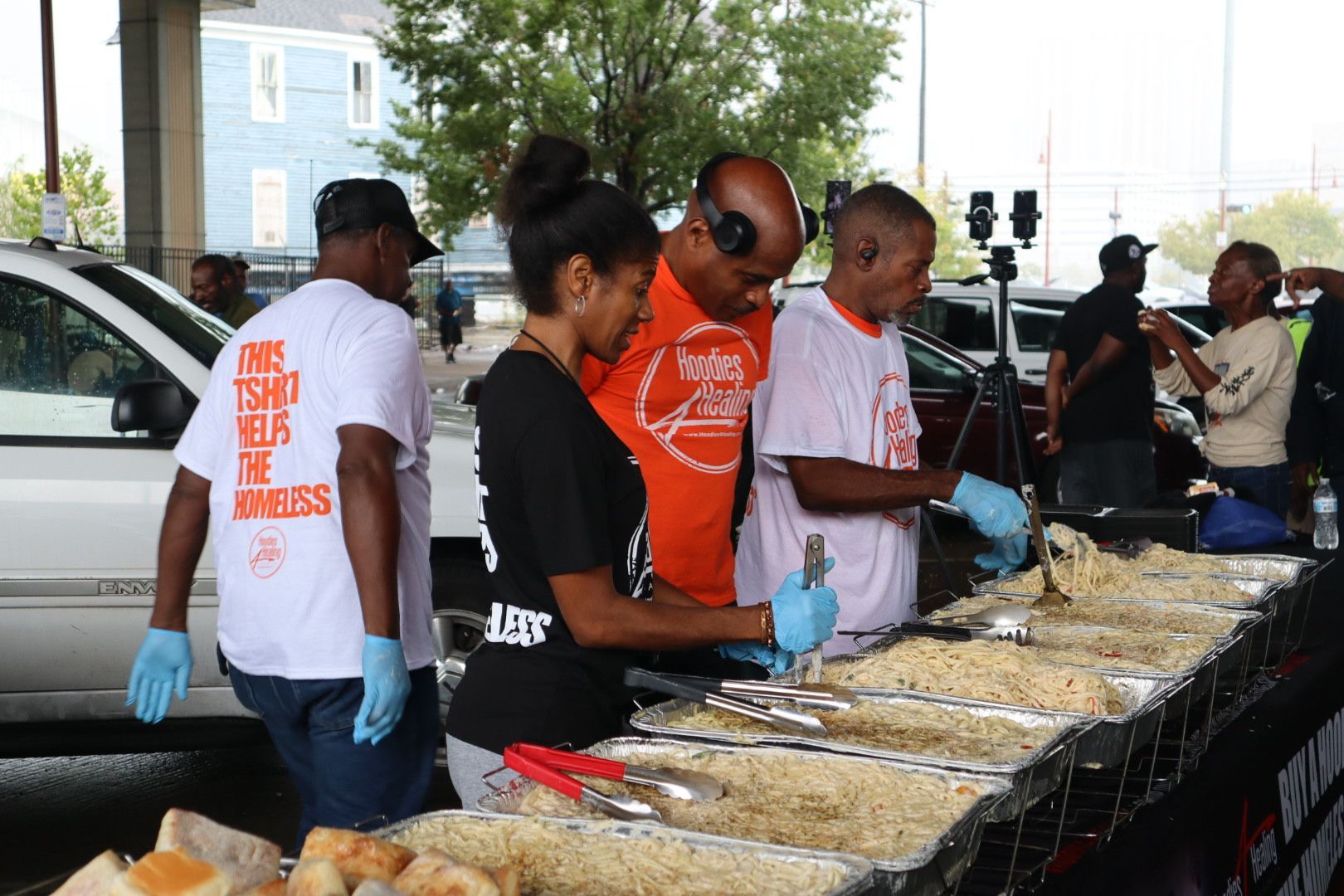A group of people are preparing food in a parking lot.