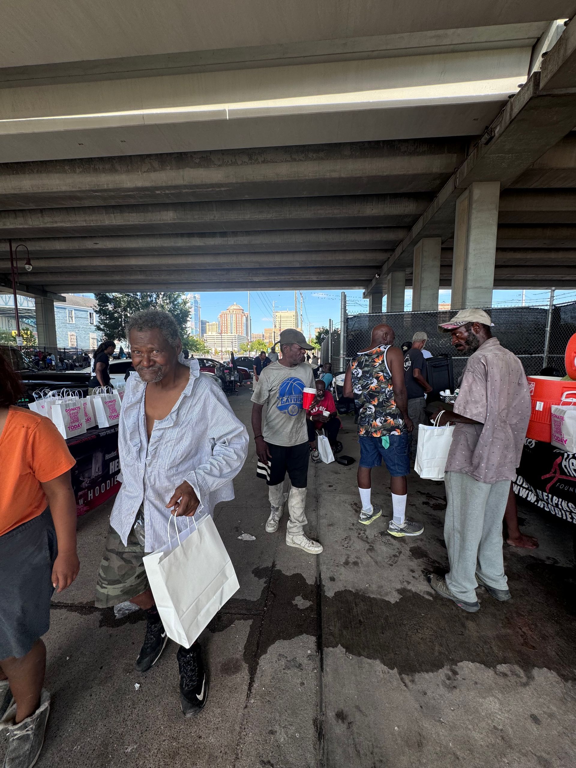 A group of people are standing under a bridge.