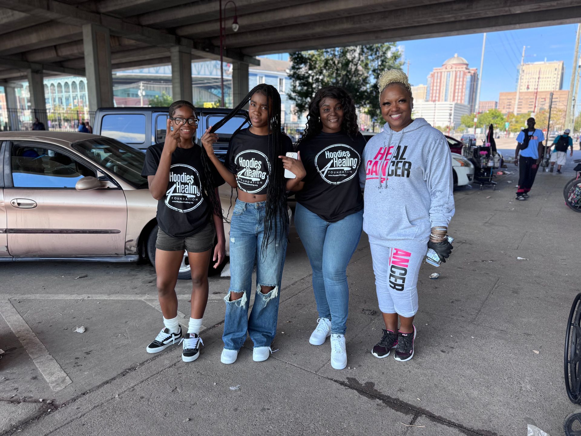 A group of women are posing for a picture in a parking lot.