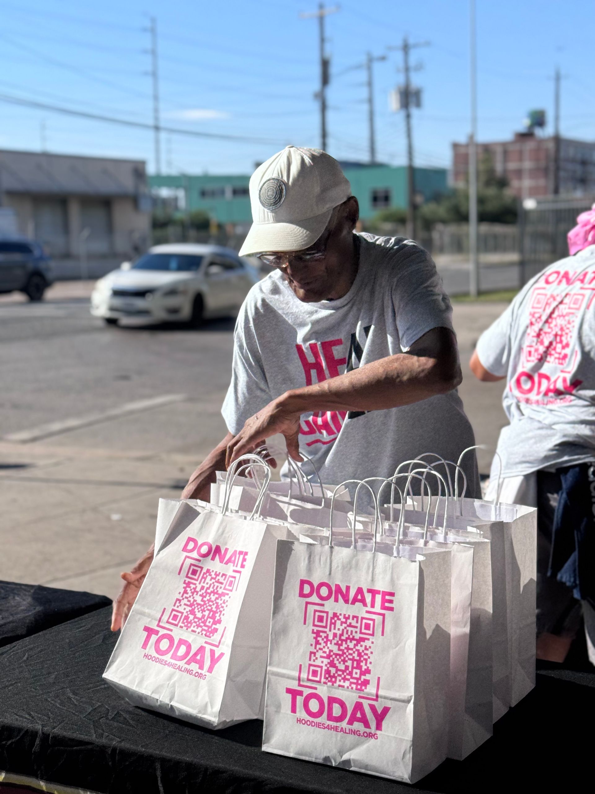 A man in a hat is putting bags on a table.