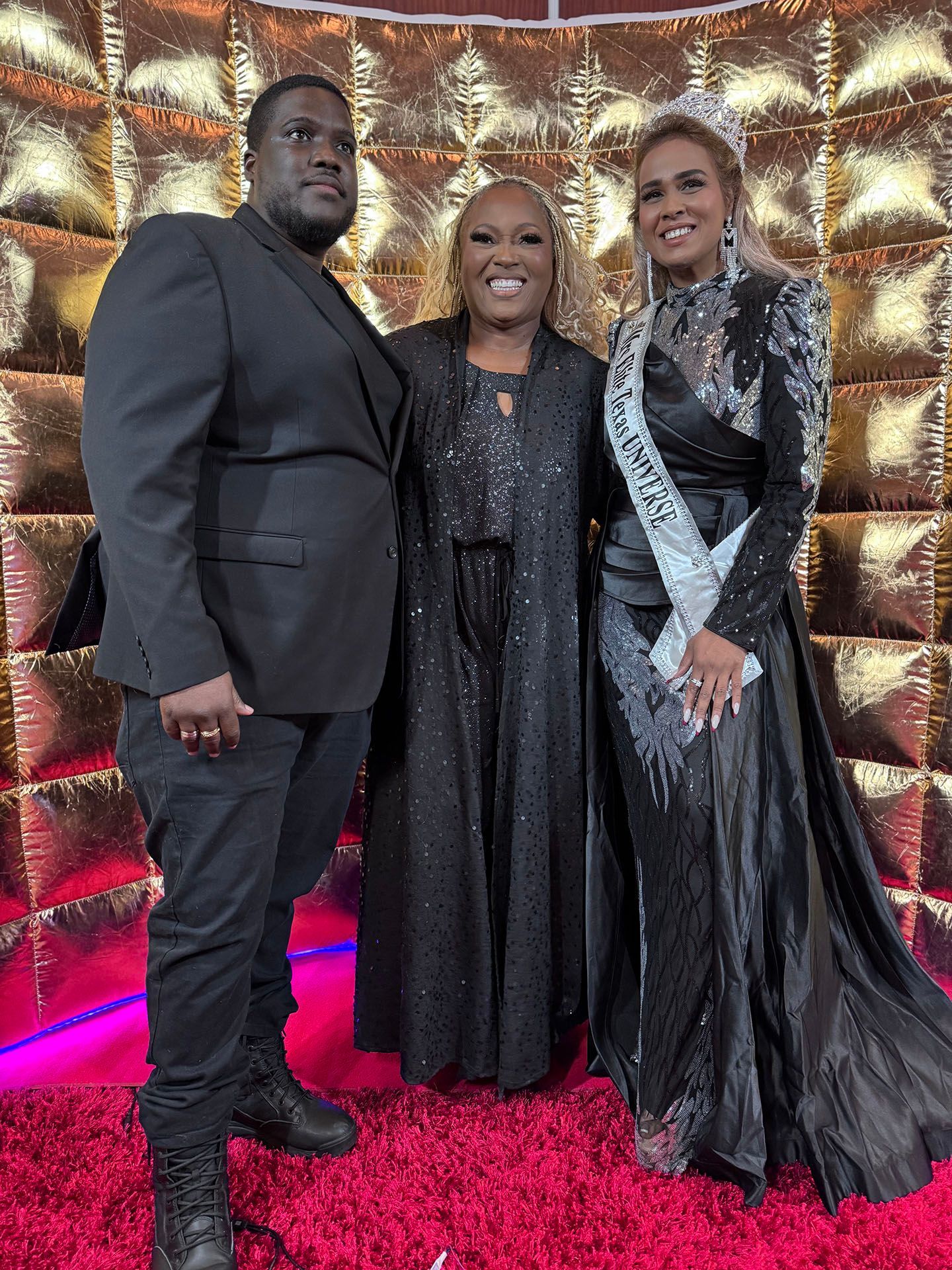 A group of people standing next to each other on a red carpet.