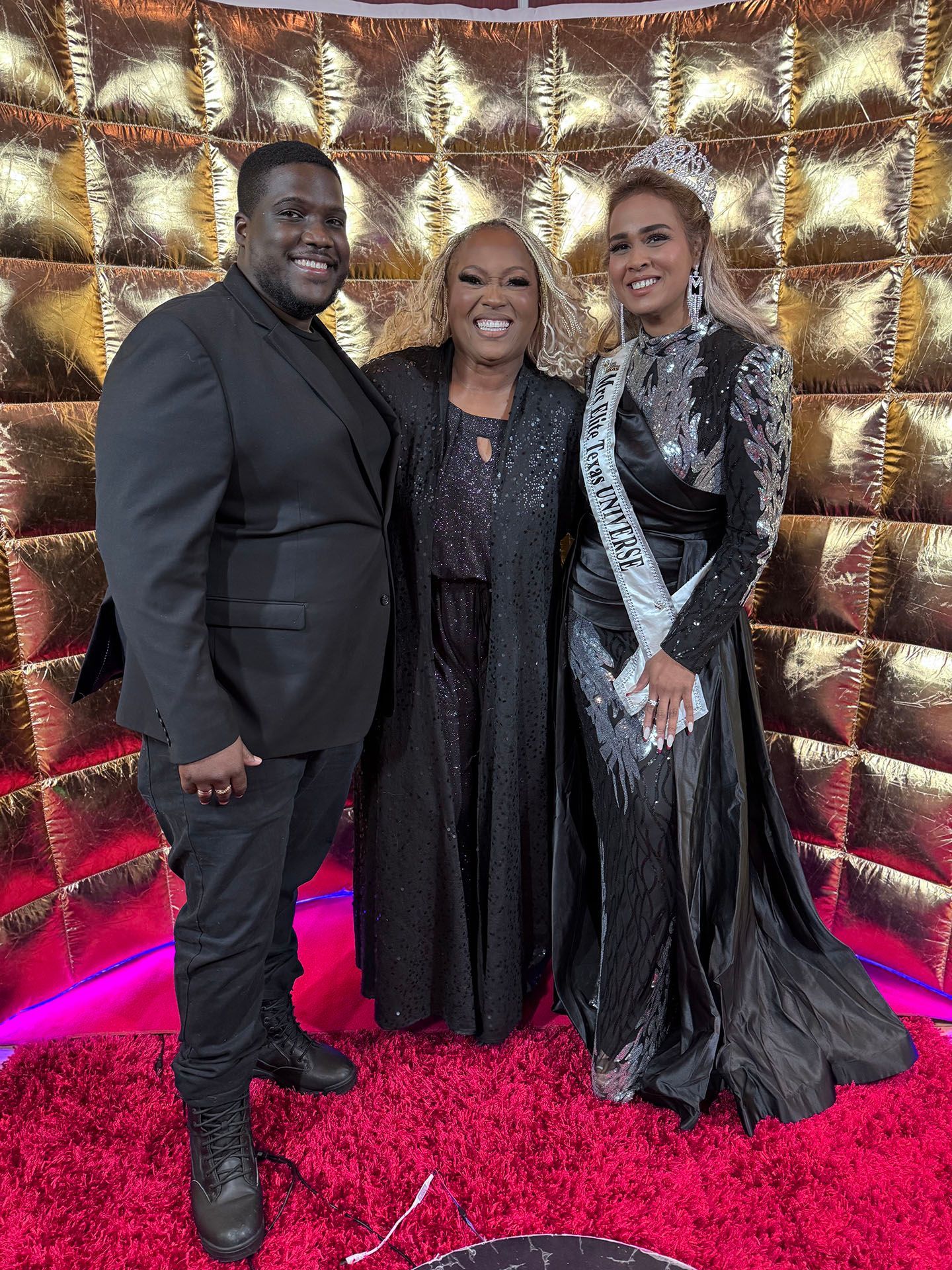 A group of people standing next to each other on a red carpet.