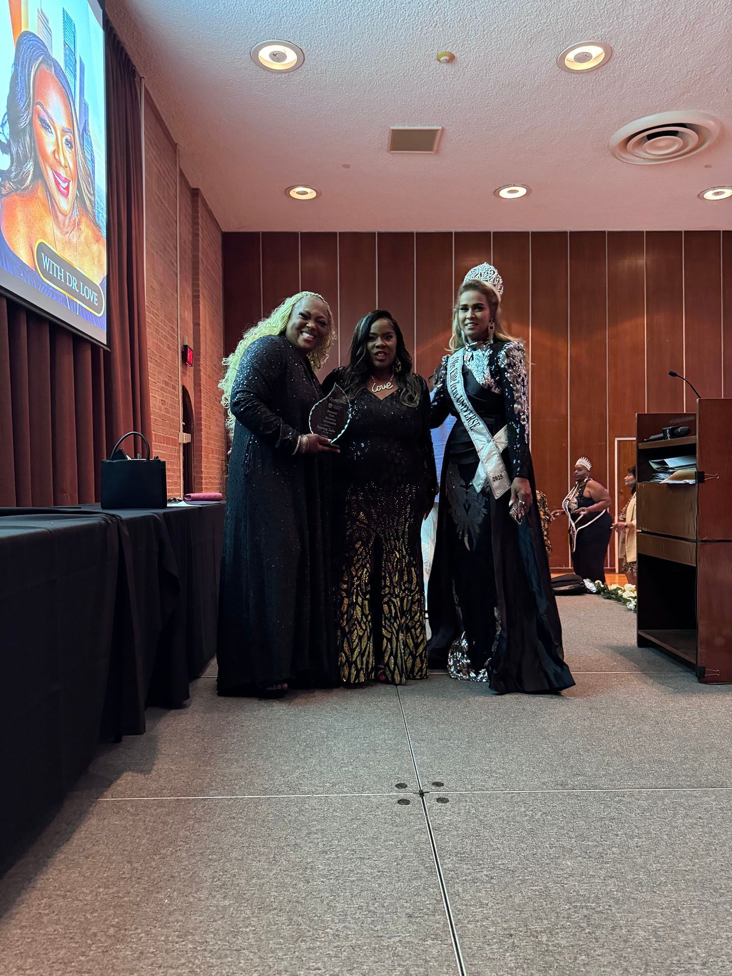 Three women are posing for a picture in a room.