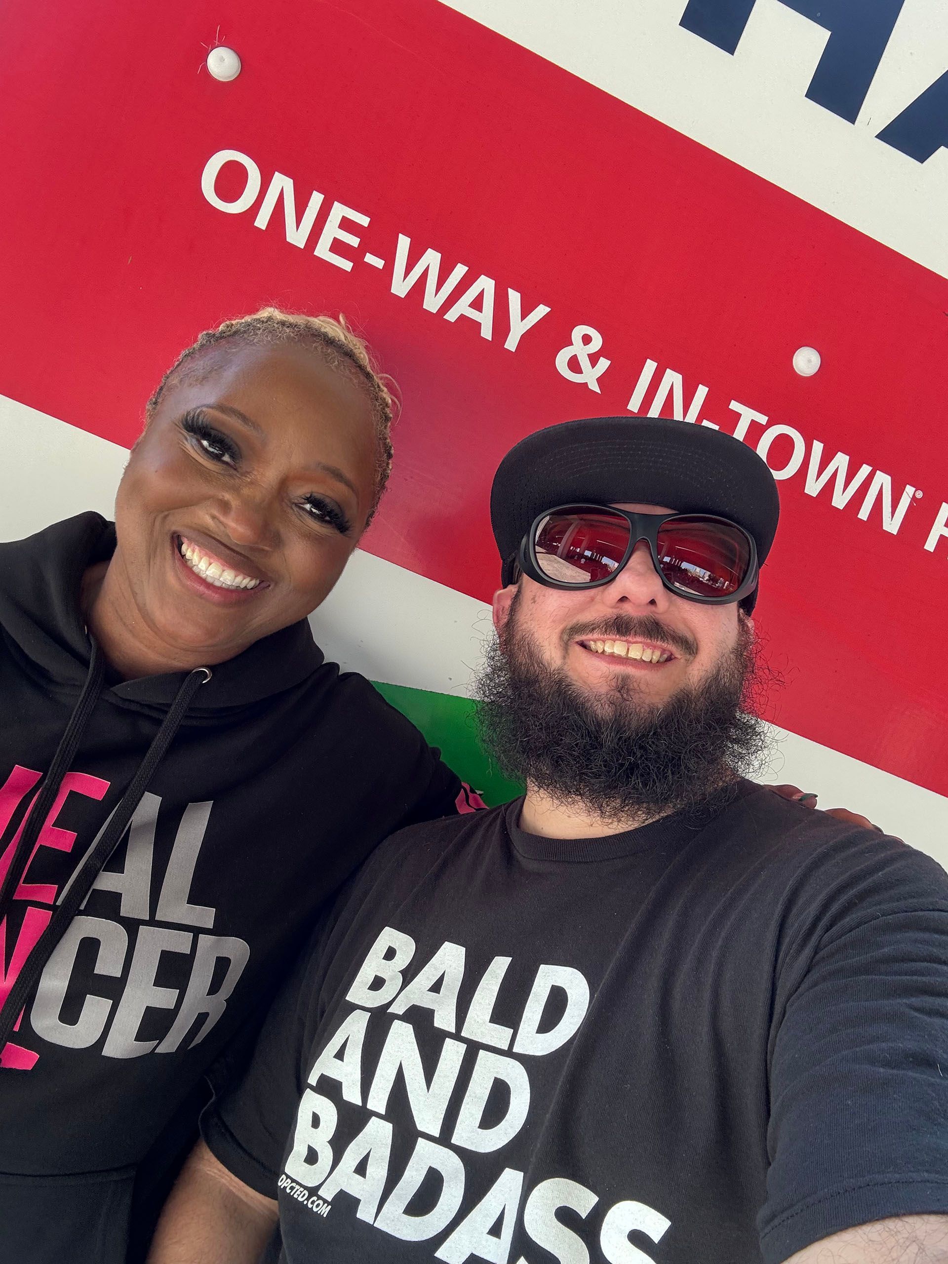 A man and a woman wearing bald and badass shirts