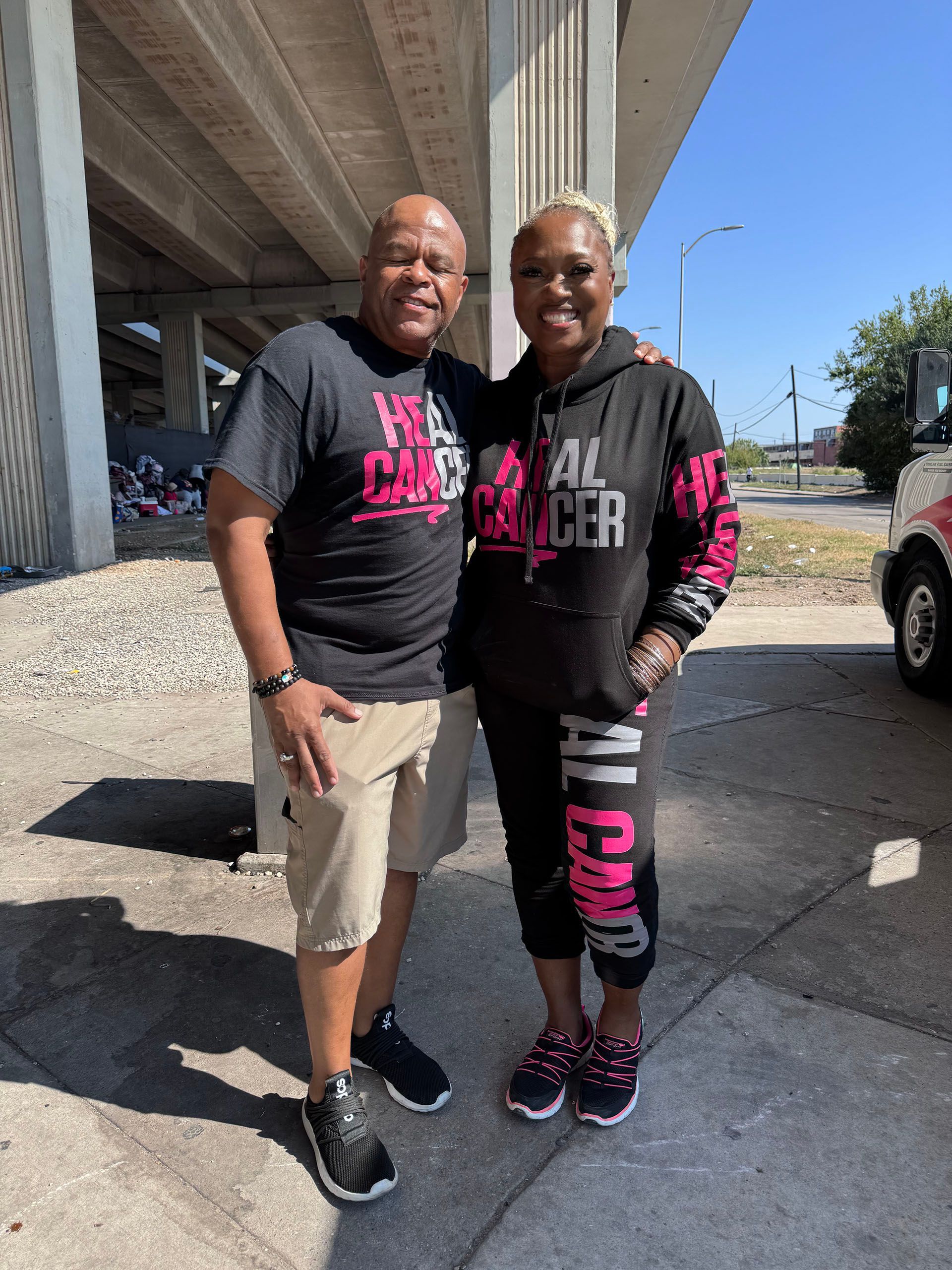 A man and a woman are standing next to each other on a sidewalk.