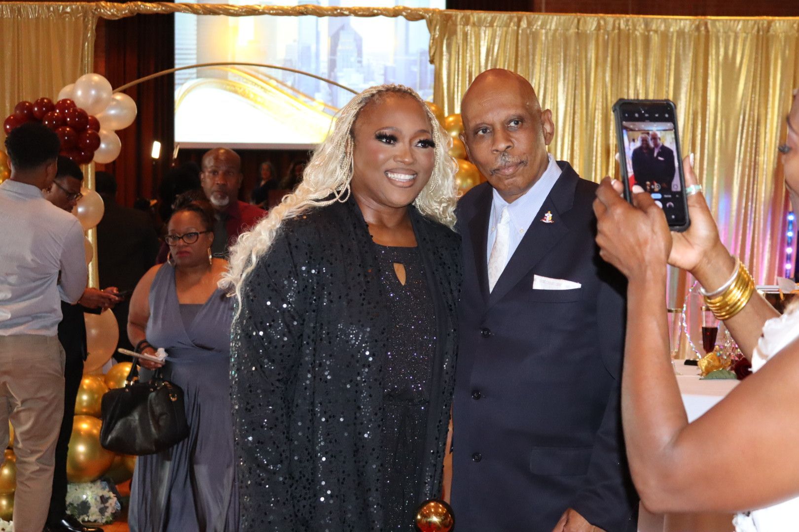 A man and a woman are posing for a picture at a party.