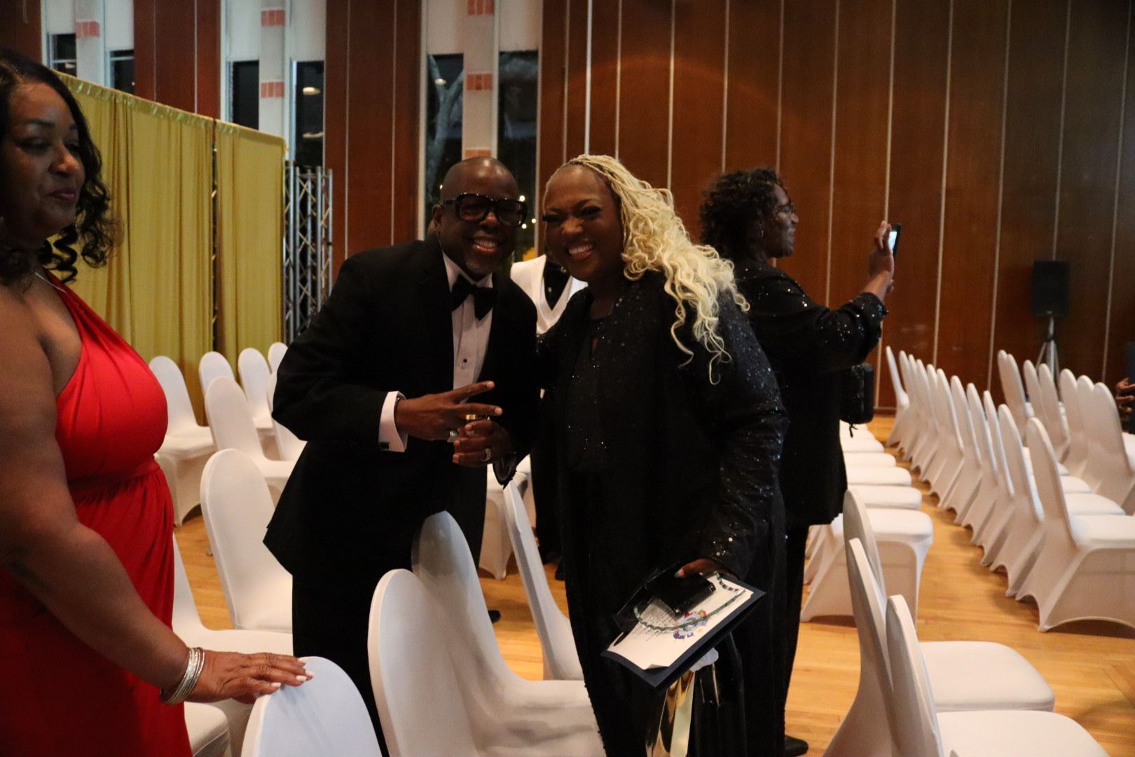 A group of people posing for a picture in a room with white chairs