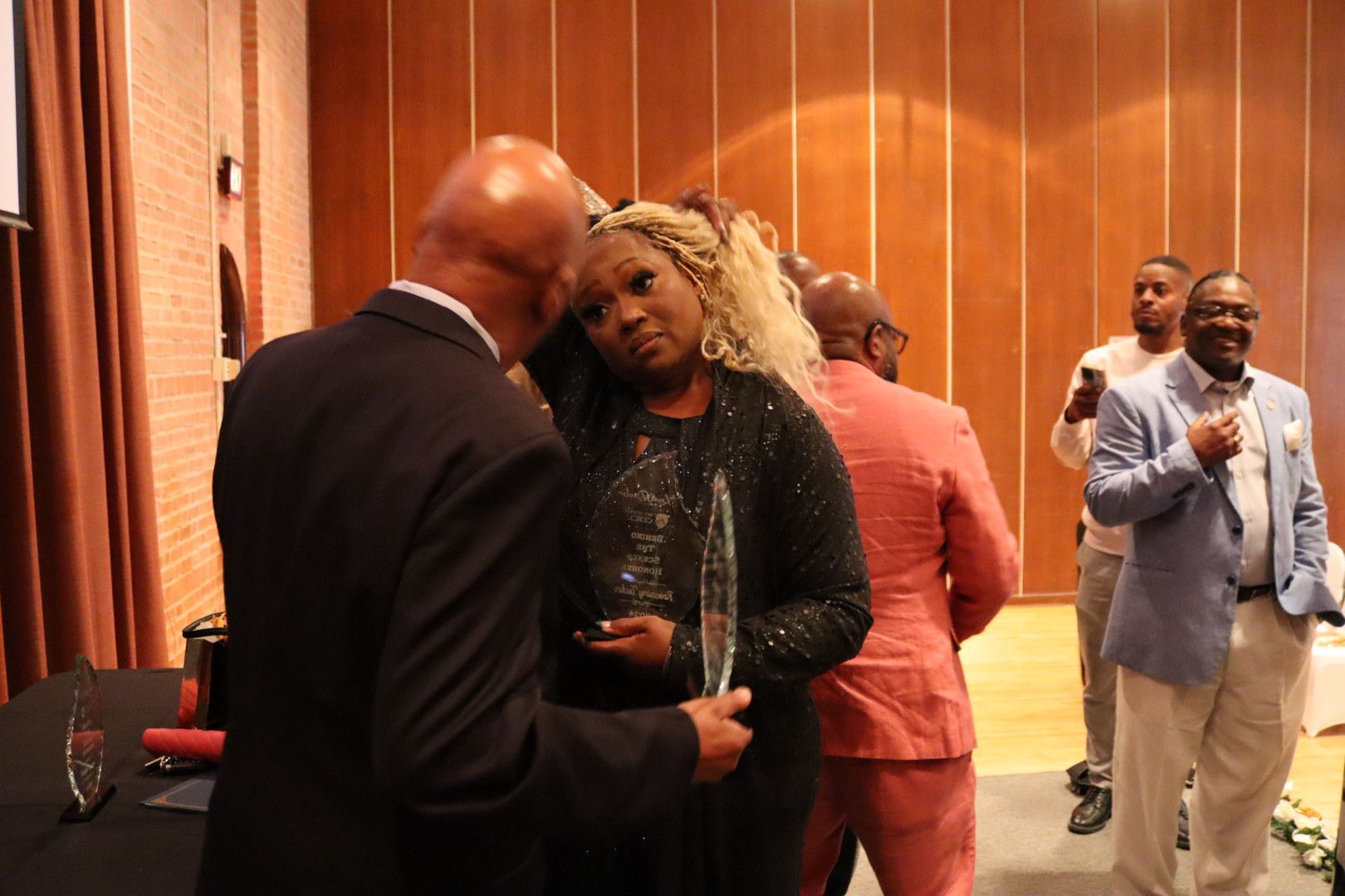 A man is giving an award to a woman in a room.