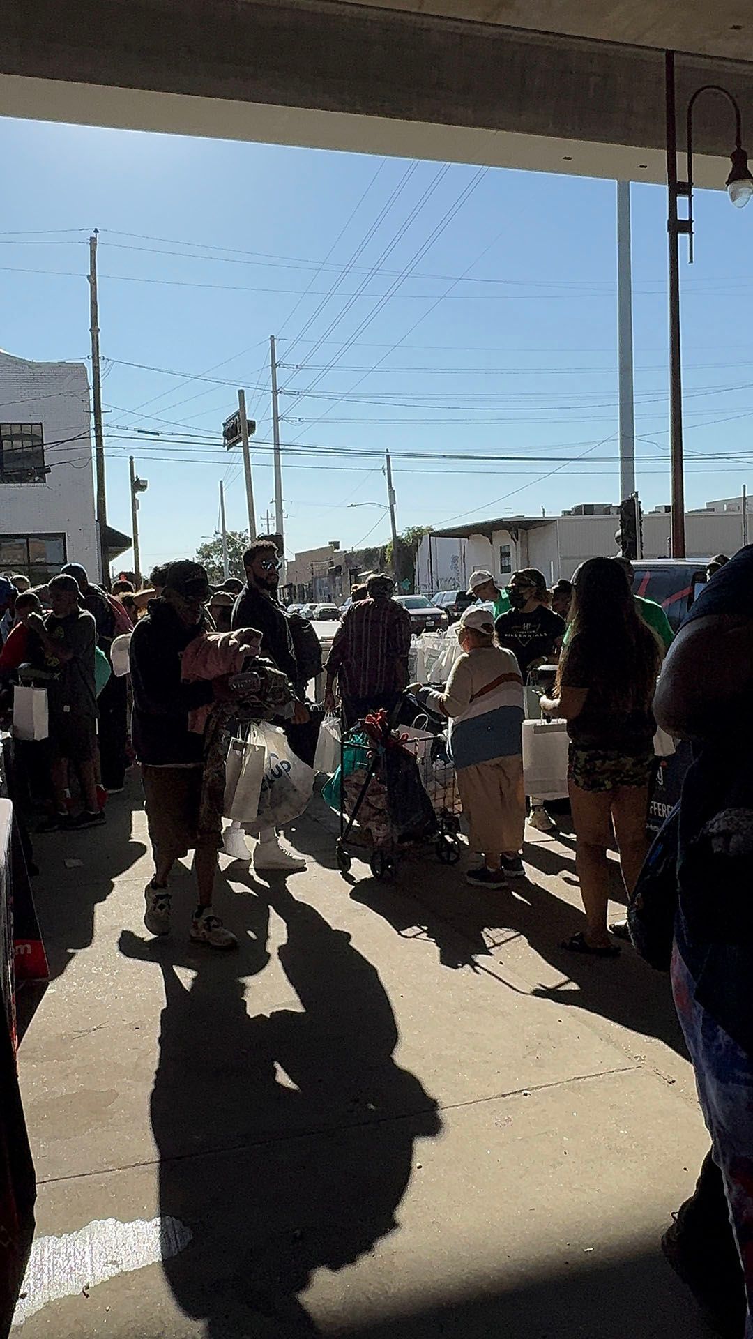 A group of people are standing in a parking lot.