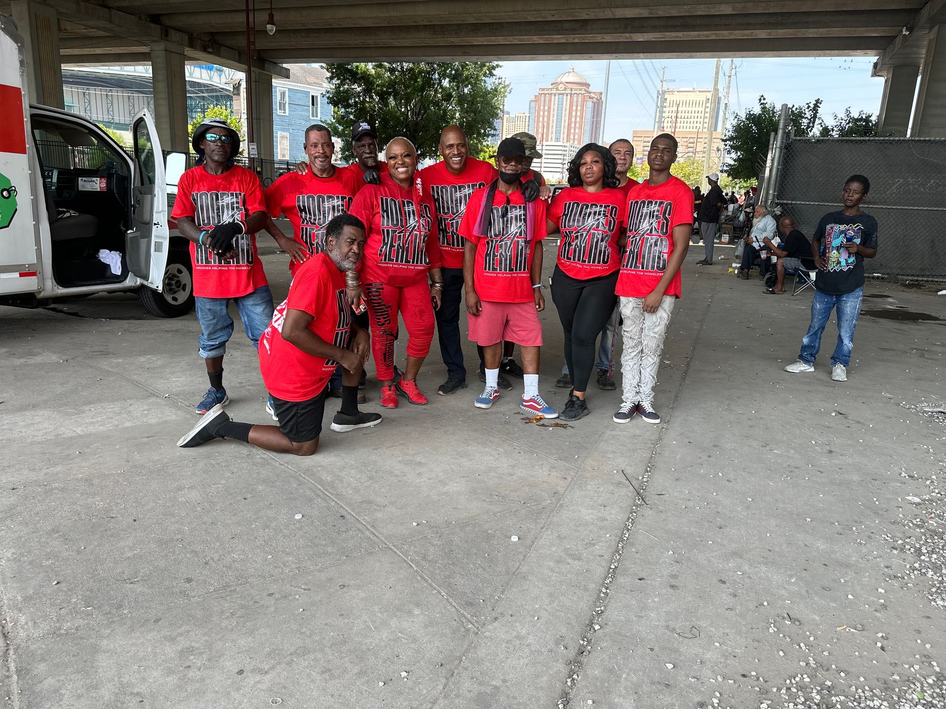 A group of people are posing for a picture under a bridge.