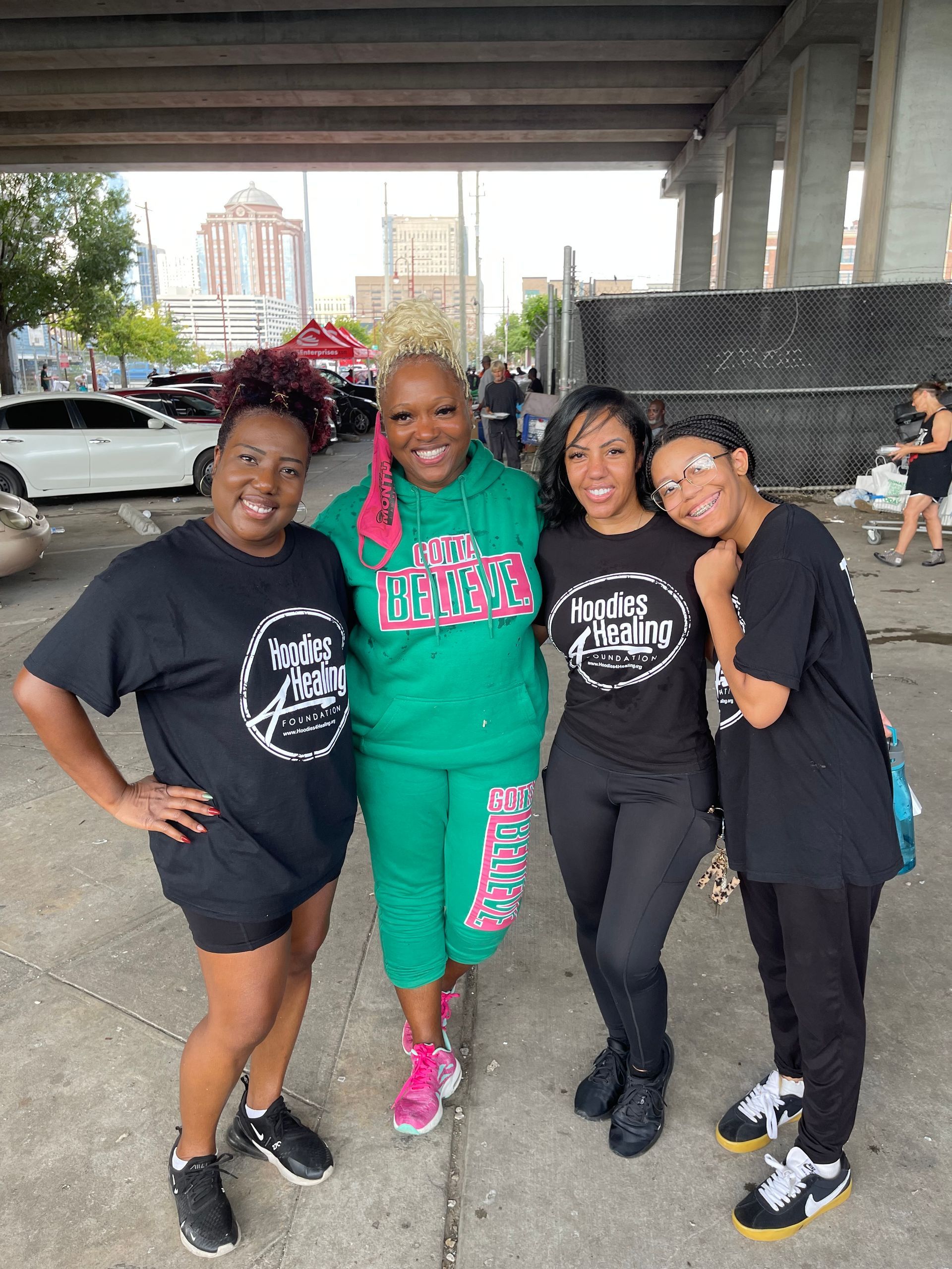 A group of women are posing for a picture in a parking lot.