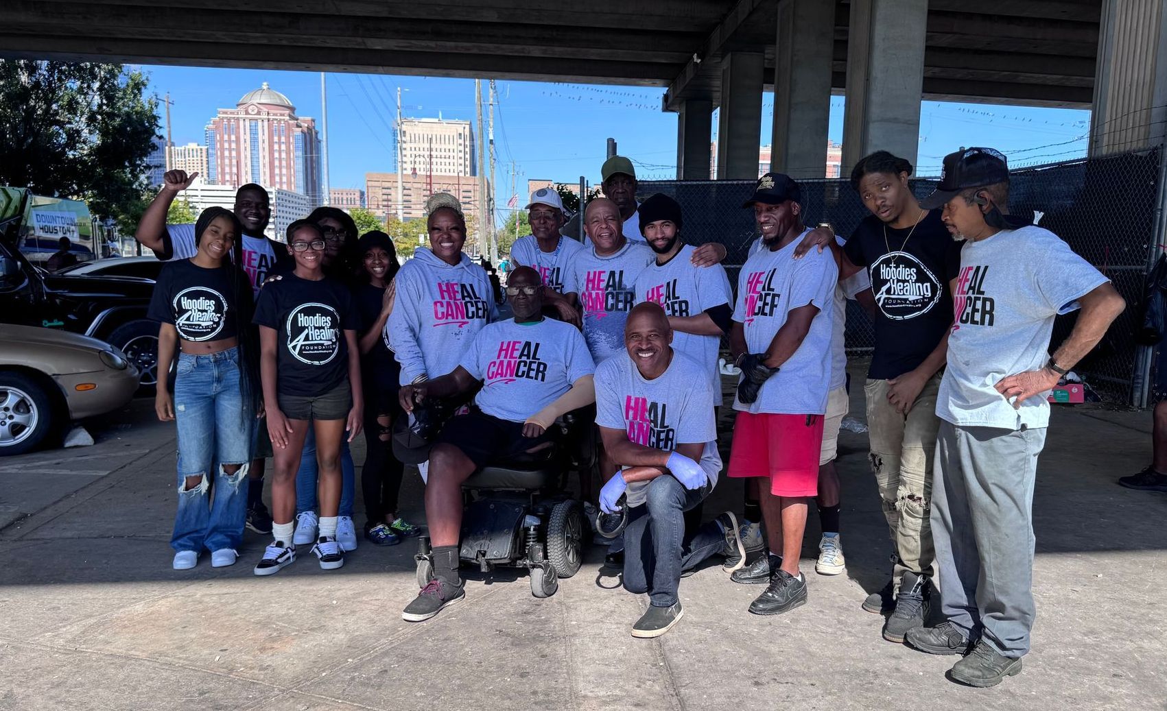 A group of people are posing for a picture in a parking lot.