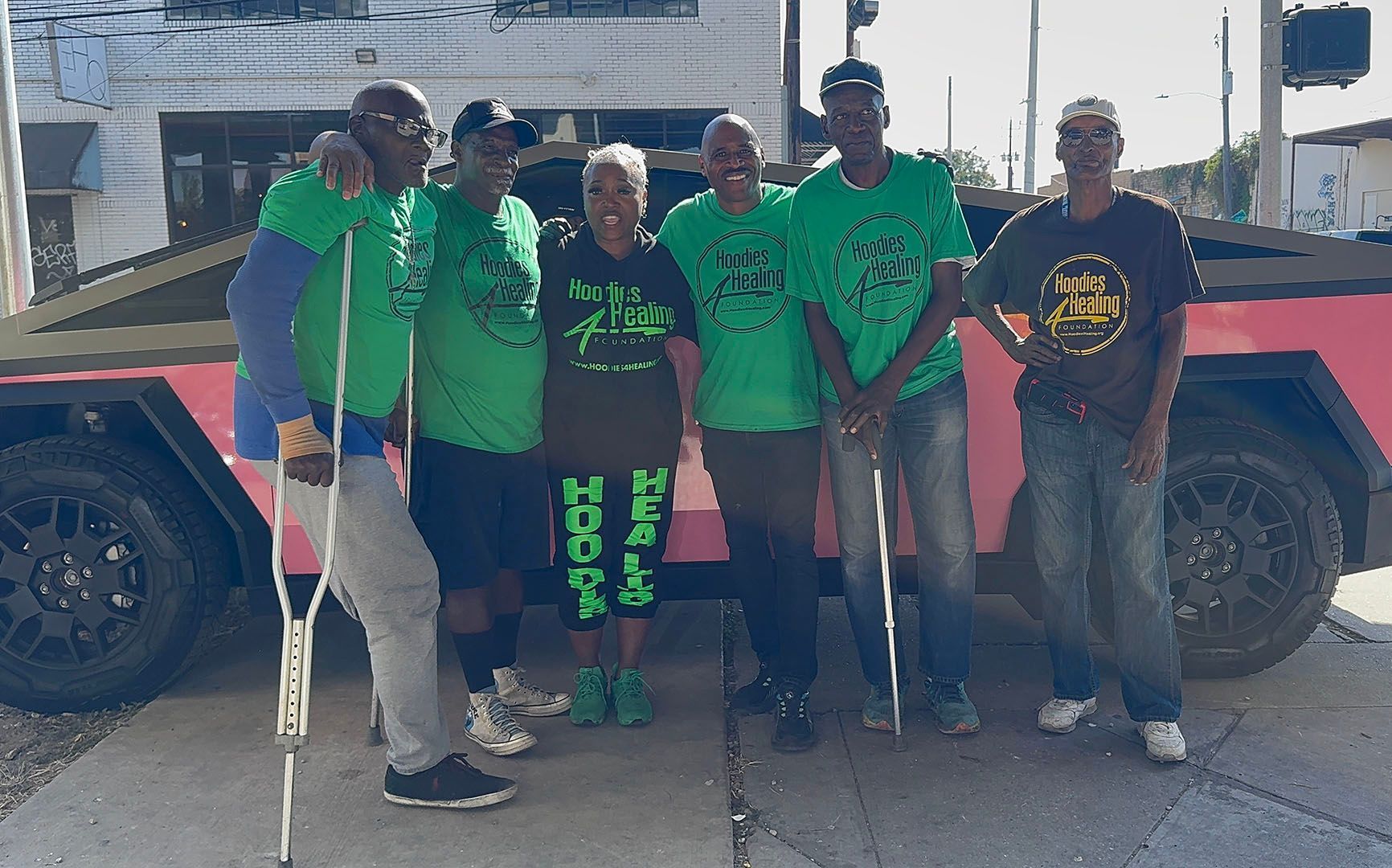 A group of people are posing for a picture in front of a red truck