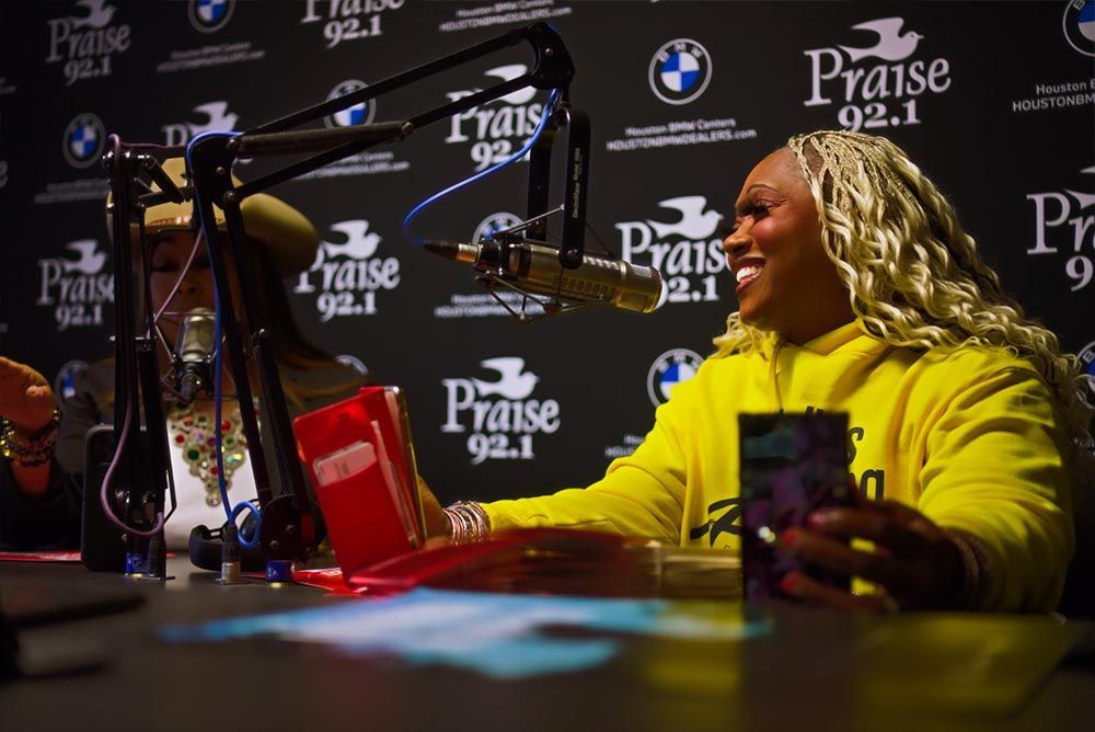 A woman is sitting at a table in front of a microphone.