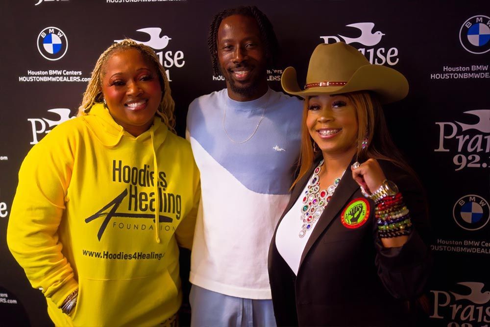 A man wearing a cowboy hat and a woman wearing a yellow hoodie are posing for a picture