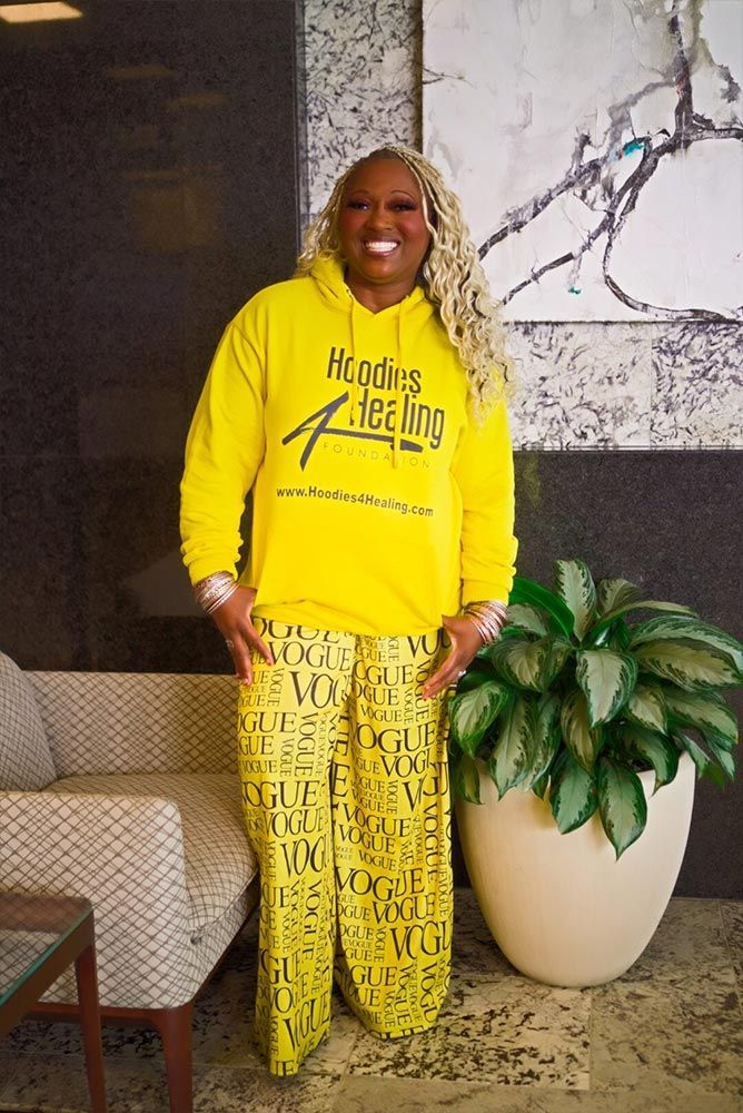 A woman is wearing a yellow hoodie and yellow pants.