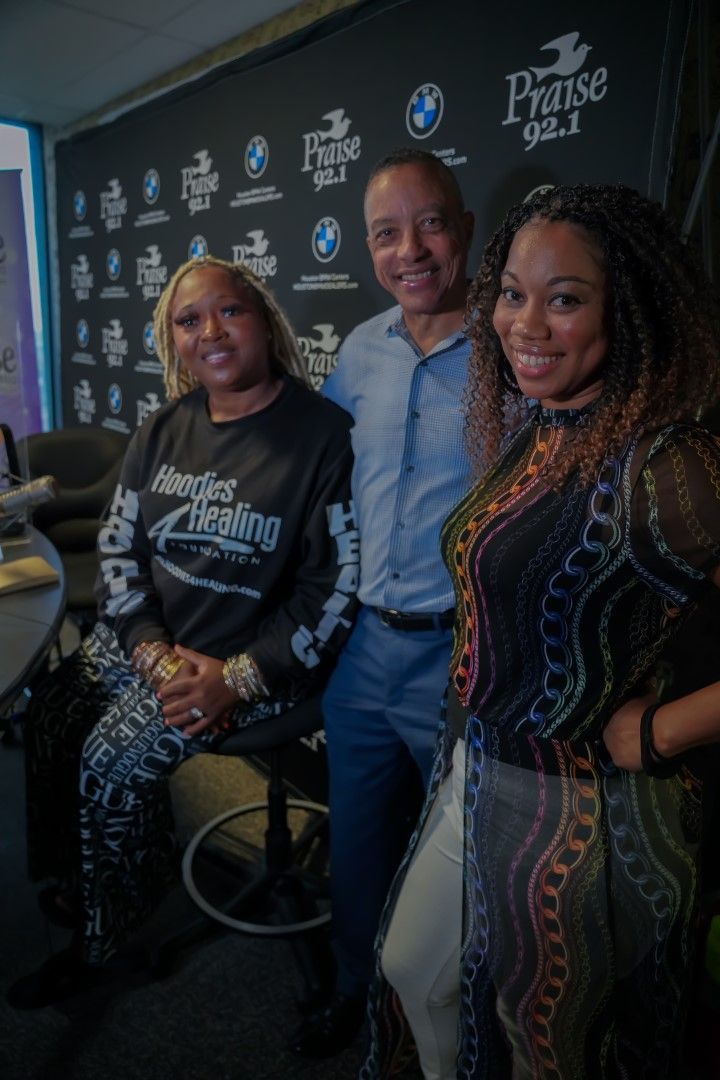 A man and two women are posing for a picture in a room.