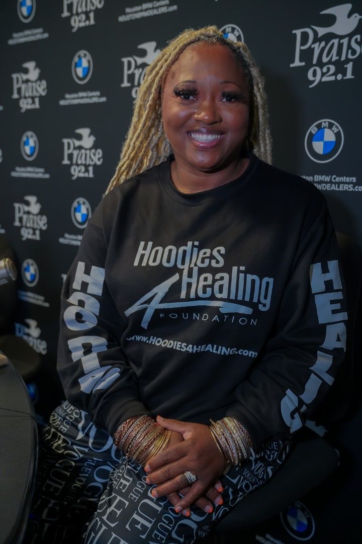 A woman wearing a hoodie that says hoodies healing