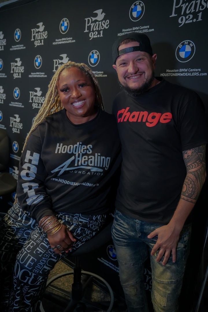 A man and a woman are posing for a picture in front of a wall.