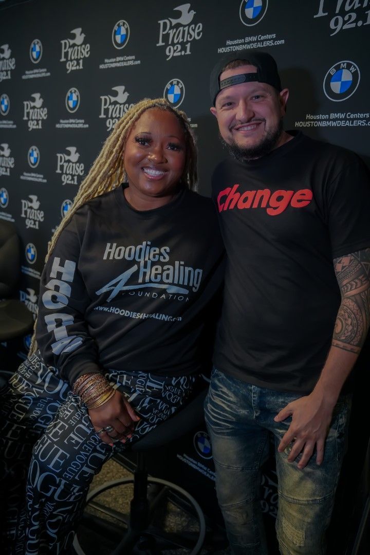 A man and a woman are posing for a picture in front of a wall.