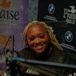 A woman is sitting in front of a microphone and smiling.