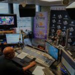 A man is sitting at a desk in a radio station.