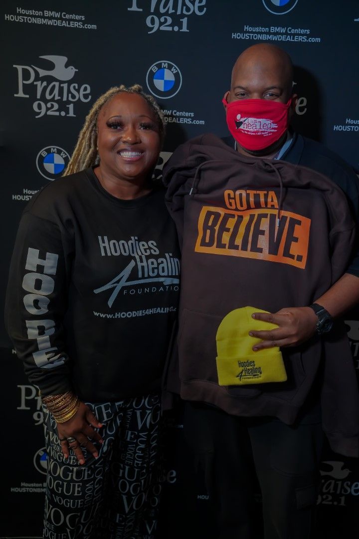 A man and a woman standing next to each other holding a shirt that says believe