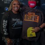 A man and a woman are posing for a picture together . the man is wearing a mask.