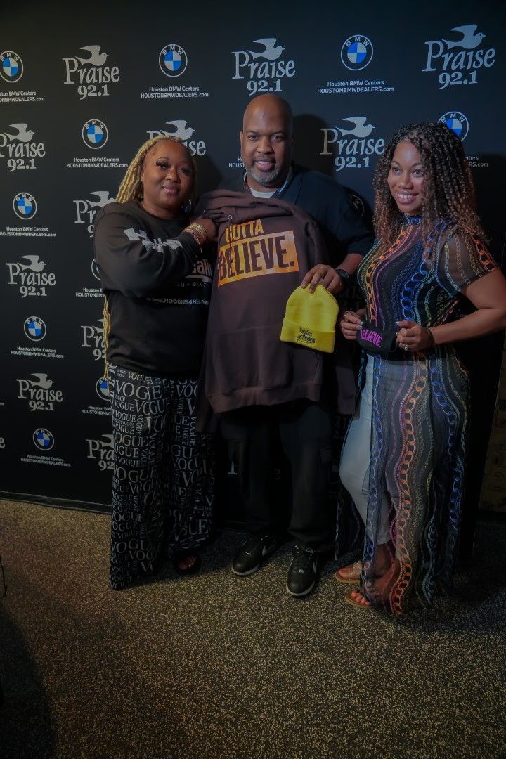 A group of people are posing for a picture in front of a wall.