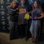 A group of people are posing for a picture in front of a wall.