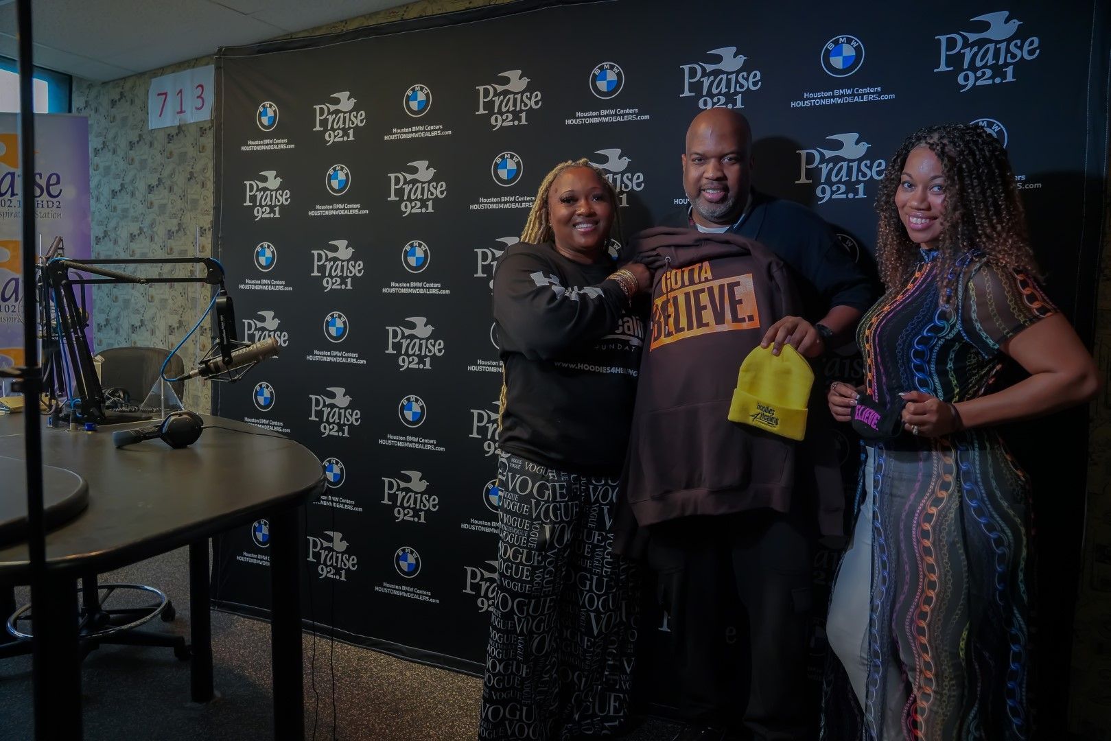 A group of people are posing for a picture in front of a microphone in a studio.