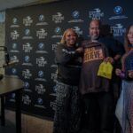 A group of people are posing for a picture in front of a blackboard.