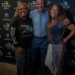 A man and two women are posing for a picture together.