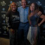 A man and two women are posing for a picture together.